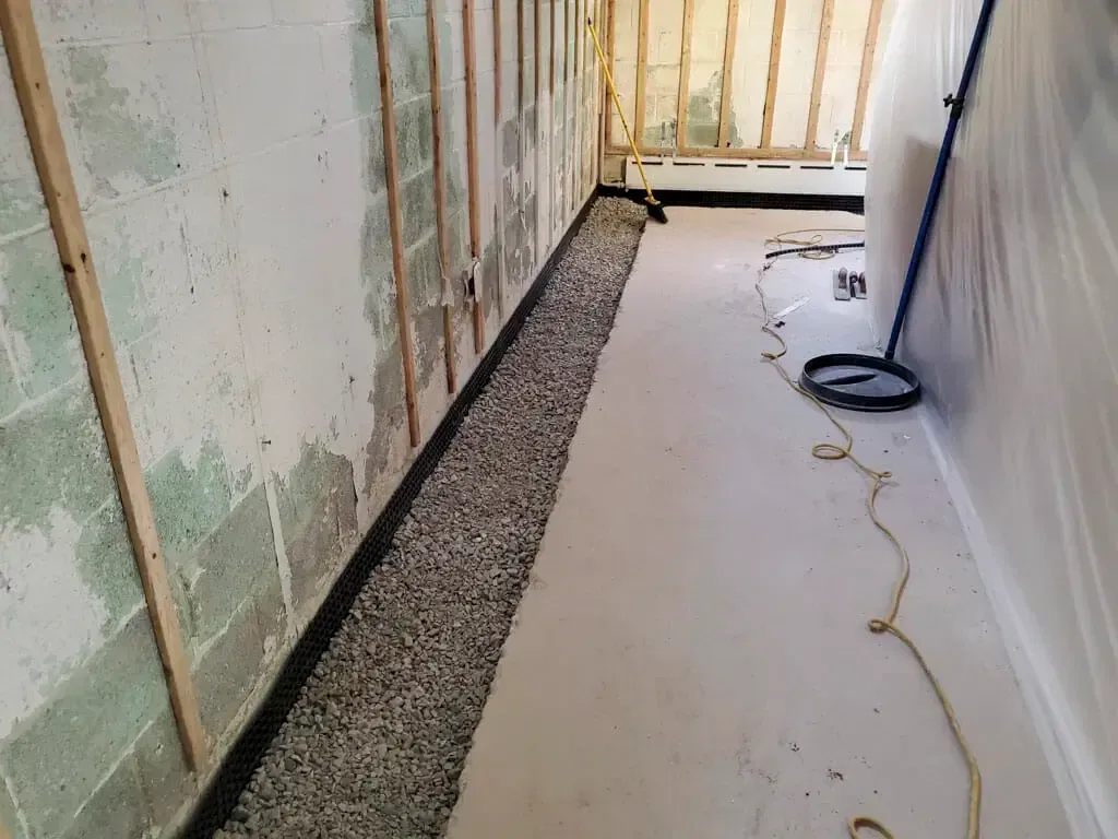 A long hallway with a drain in the middle of it.