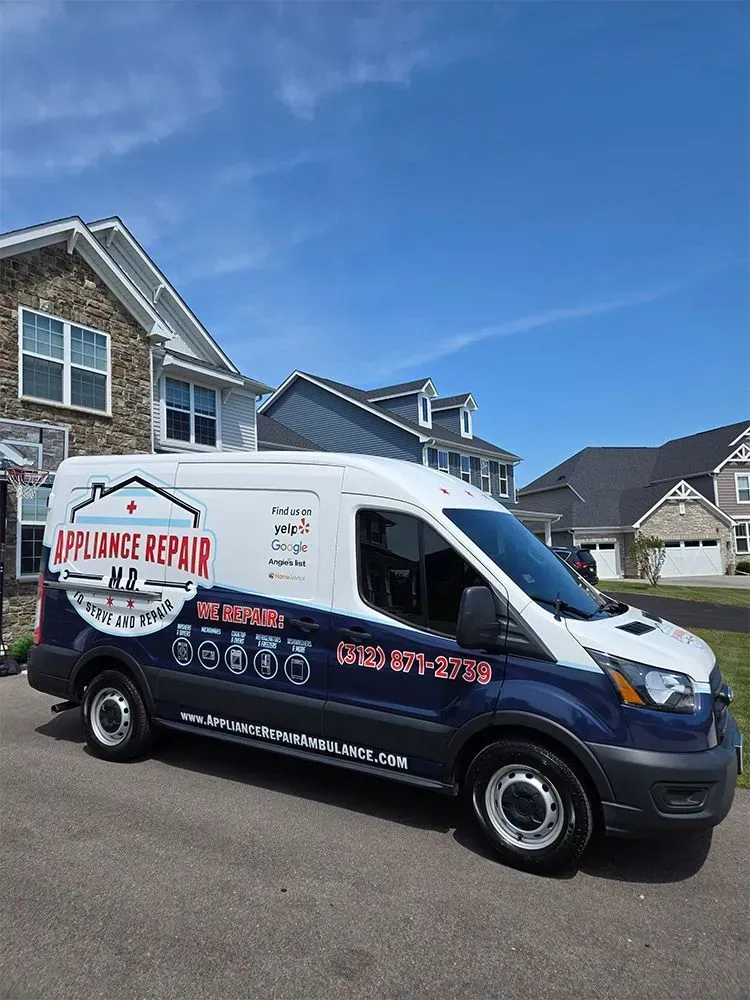White and blue appliance repair van parked in front of houses on a sunny day.