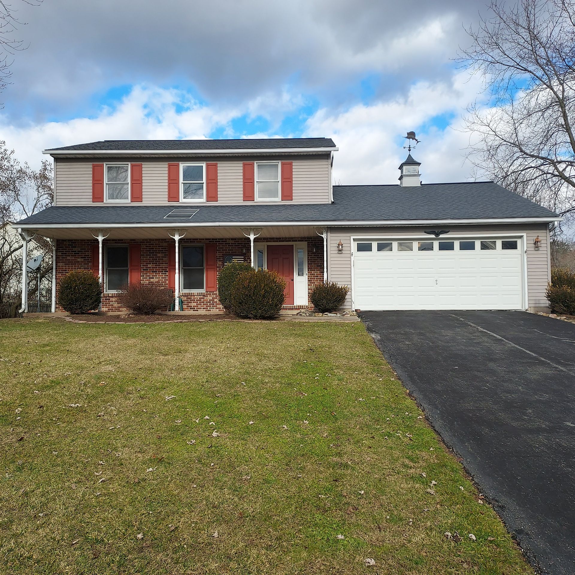 A house with red shutters and a white garage door