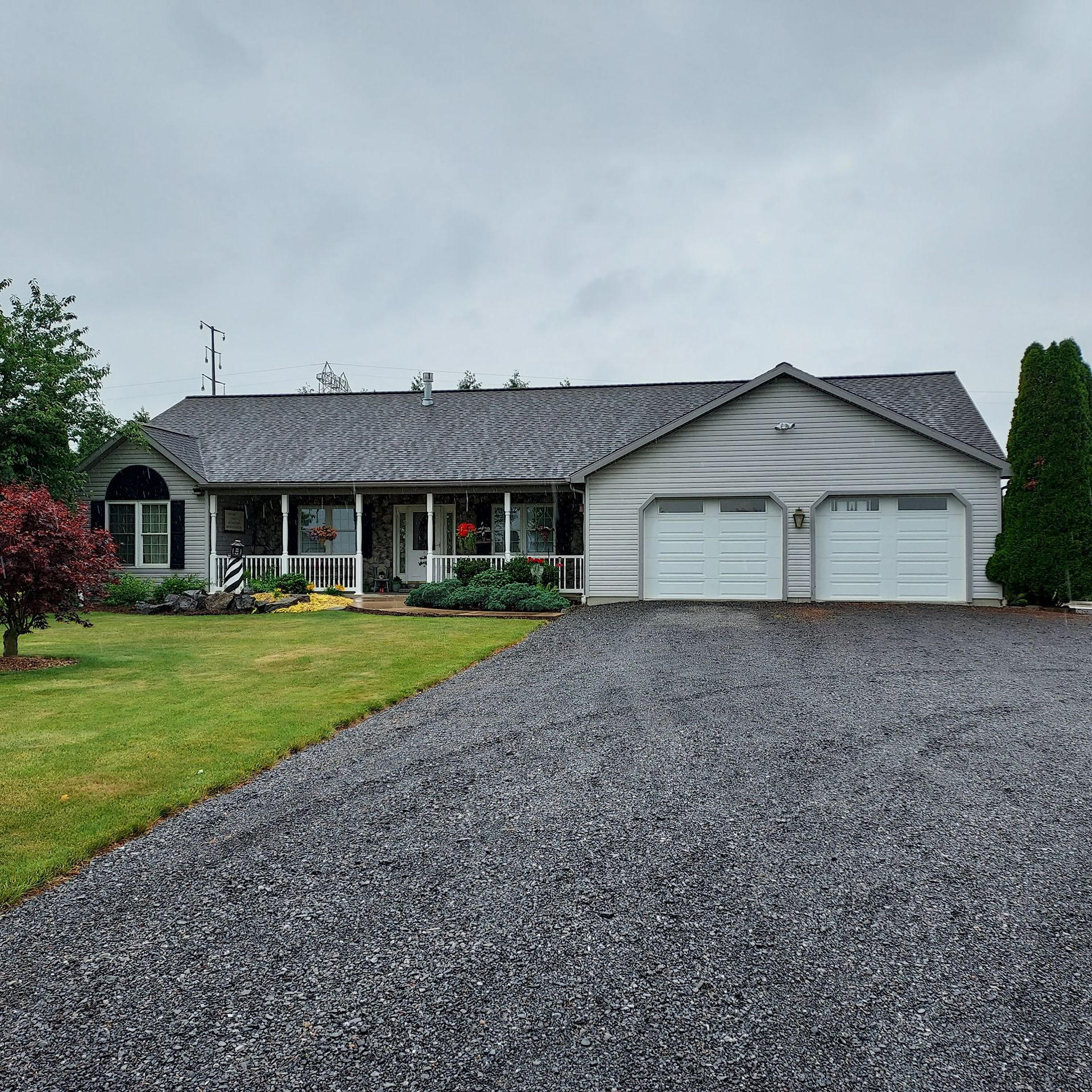 A house with two garage doors and a gravel driveway