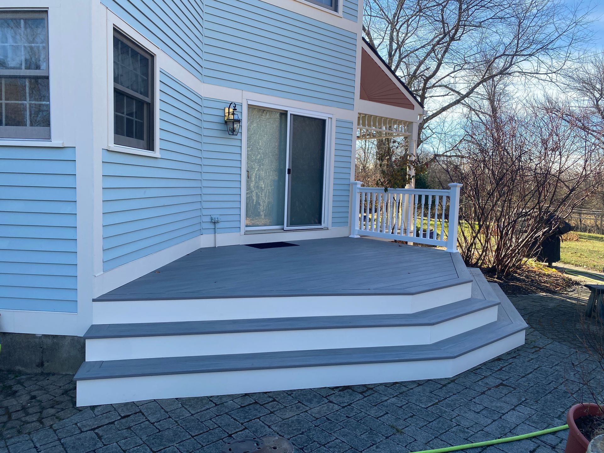 A blue house with a white deck and stairs