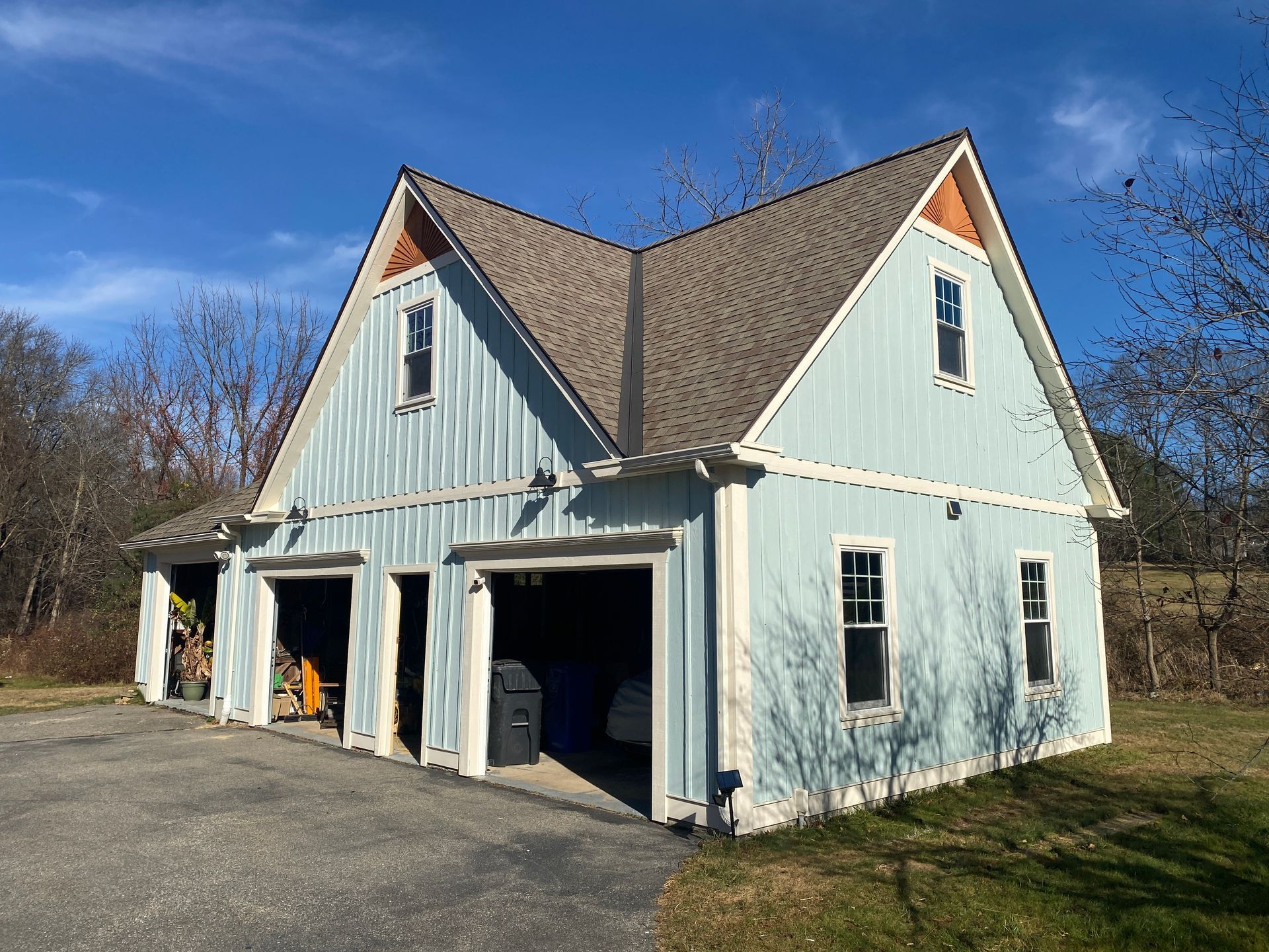 A blue and white house with a garage and a driveway.