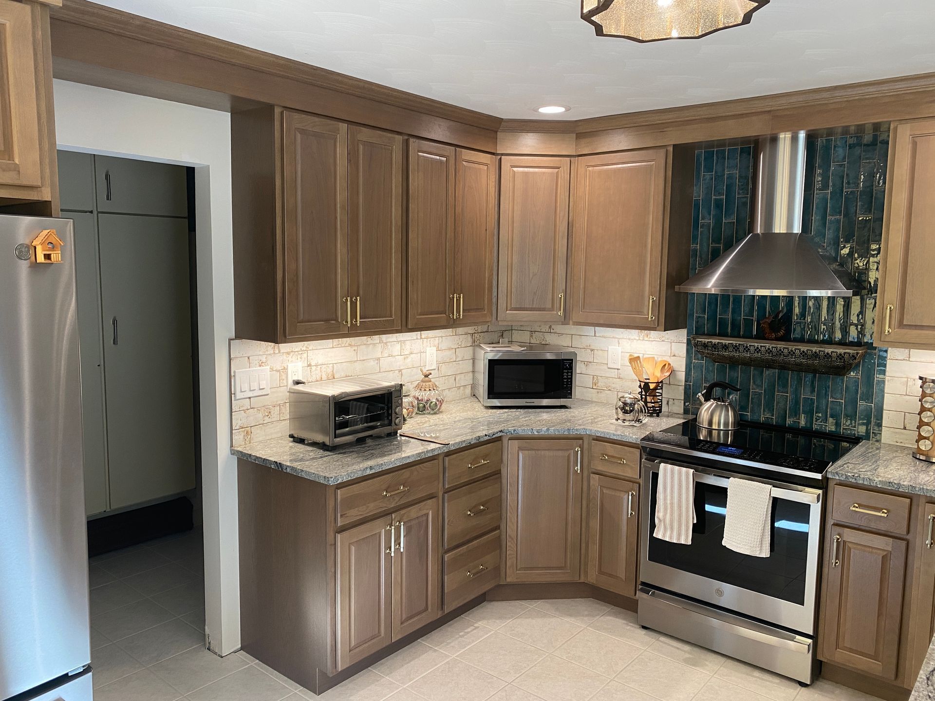 A kitchen with stainless steel appliances and wooden cabinets.