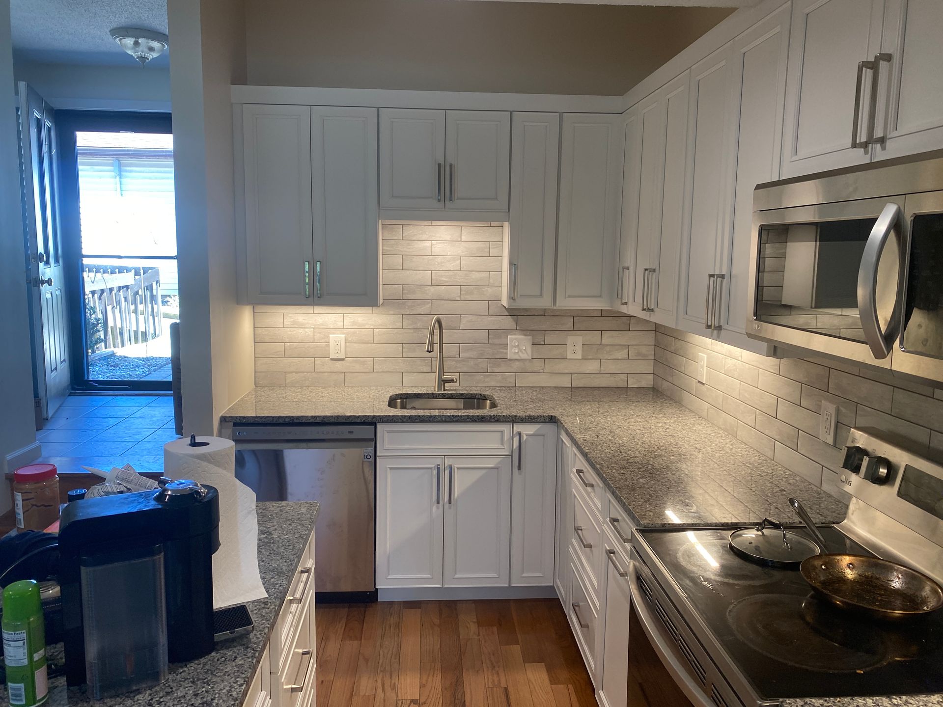A kitchen with white cabinets and stainless steel appliances