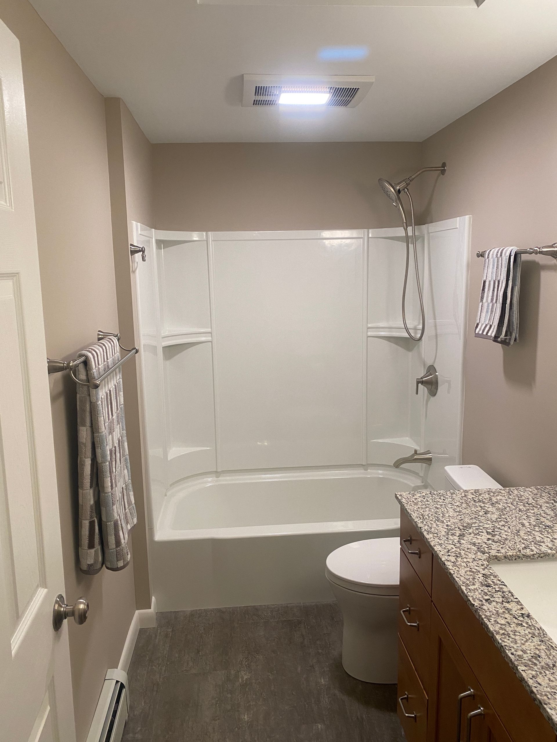 A bathroom with a tub , toilet , sink and shower.