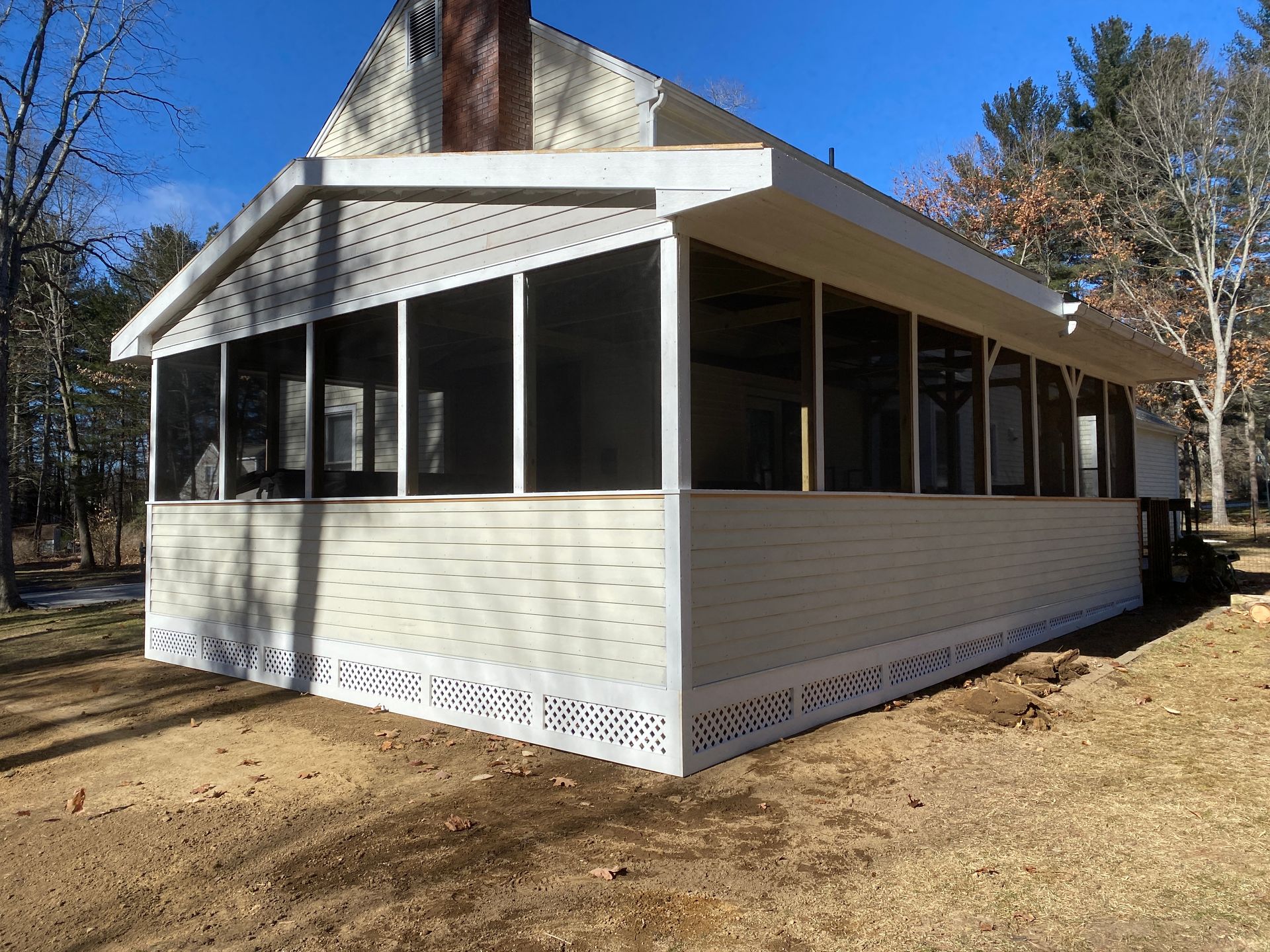 A screened in porch on the side of a house