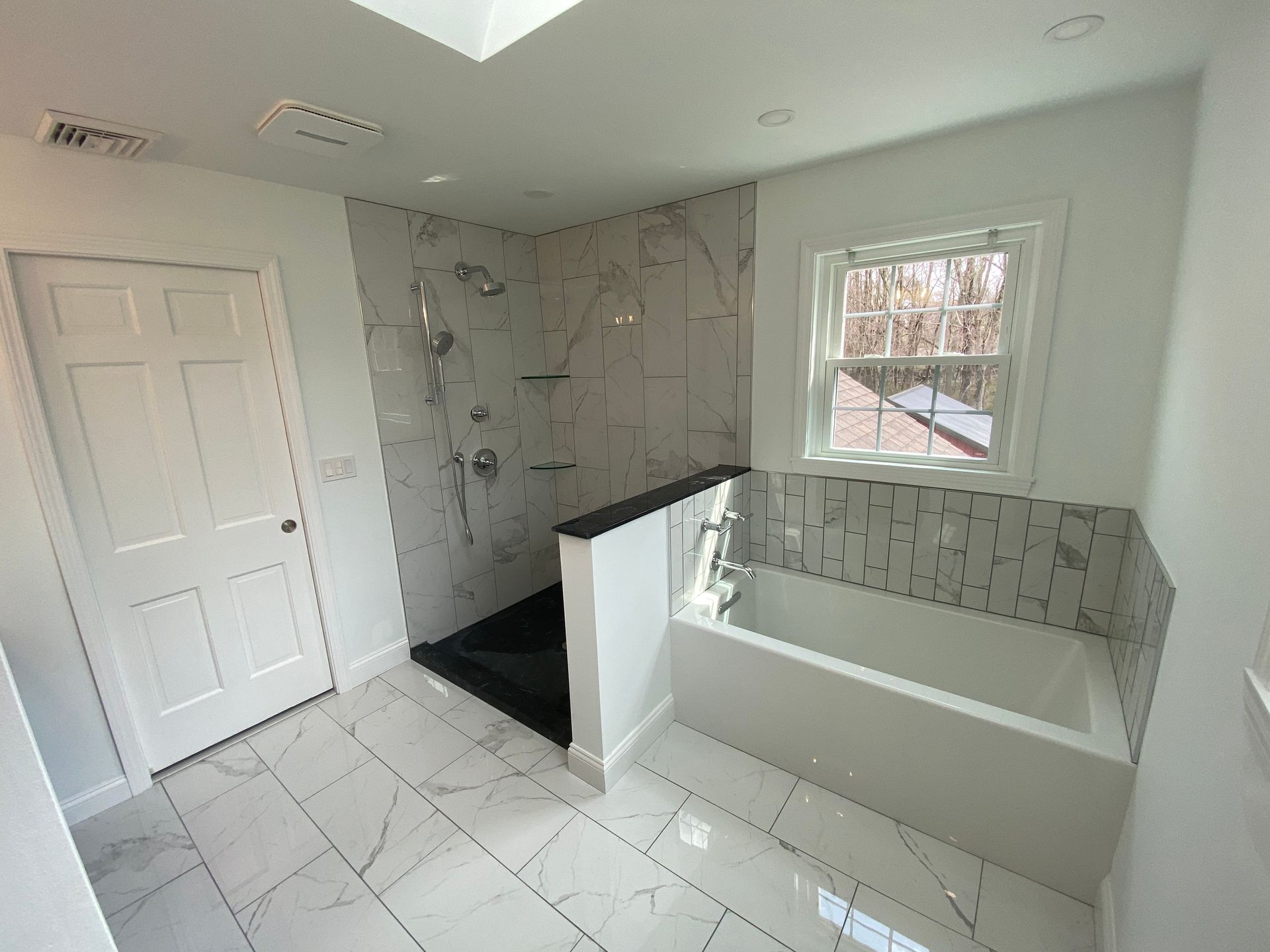 A bathroom with a tub , shower , and window.