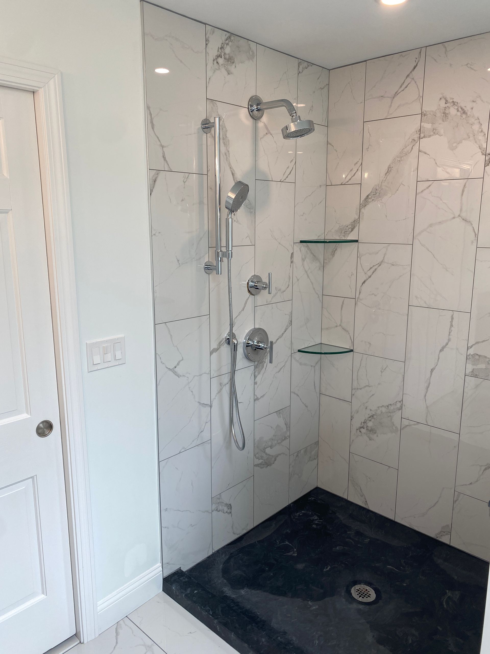 A bathroom with marble tiles and a walk in shower