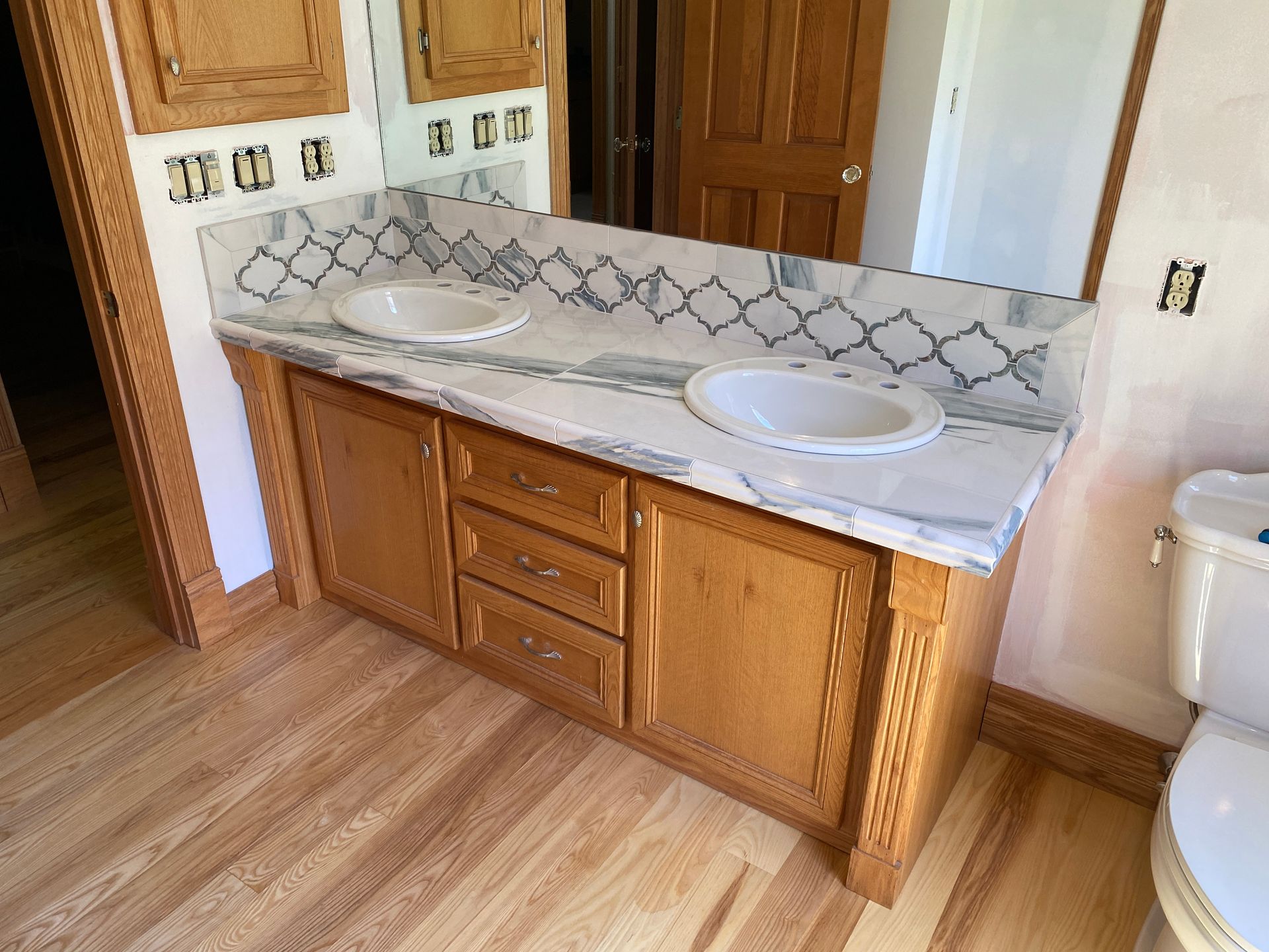A bathroom with two sinks and a toilet.