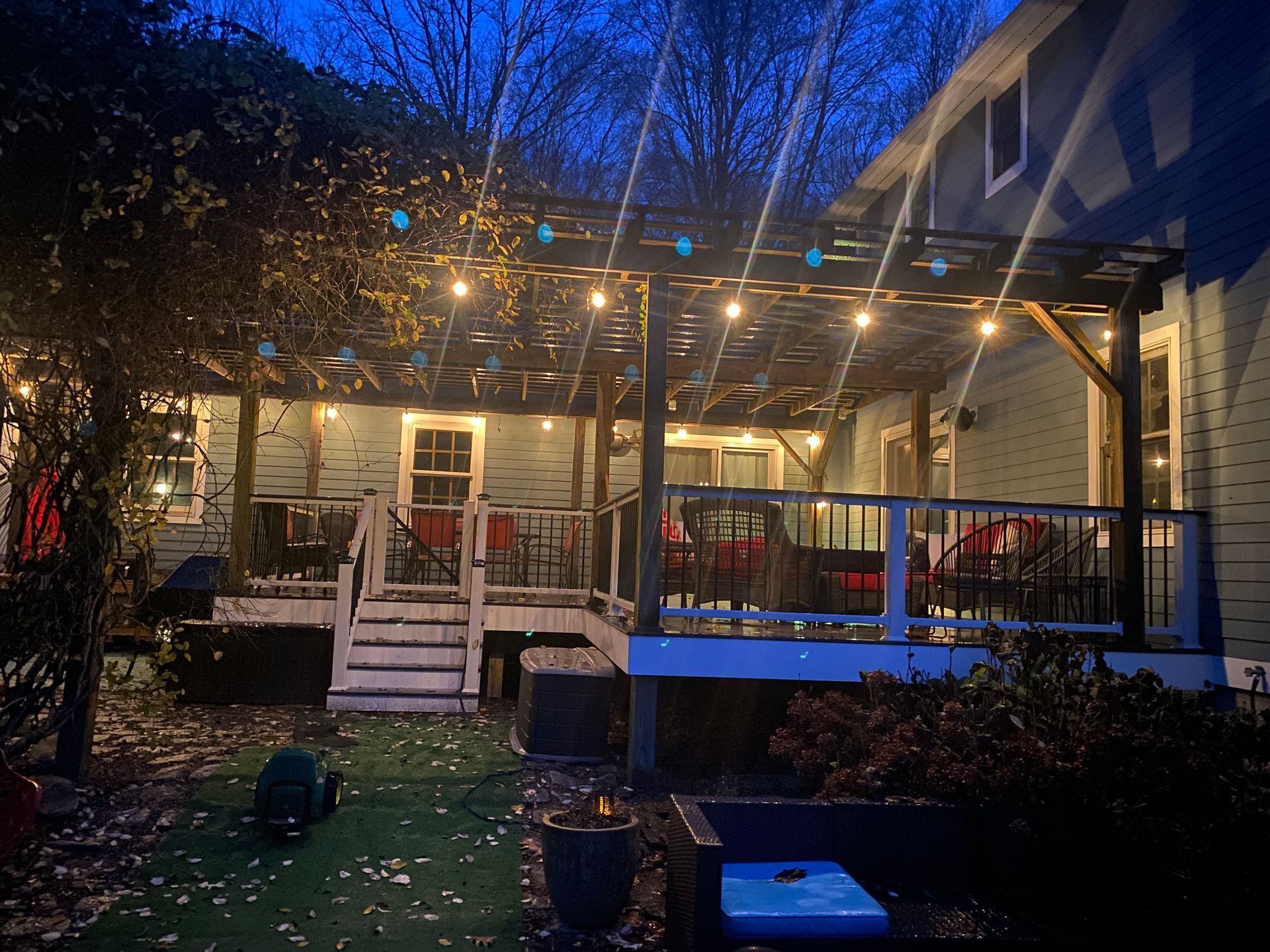 A house with a large deck and stairs at night