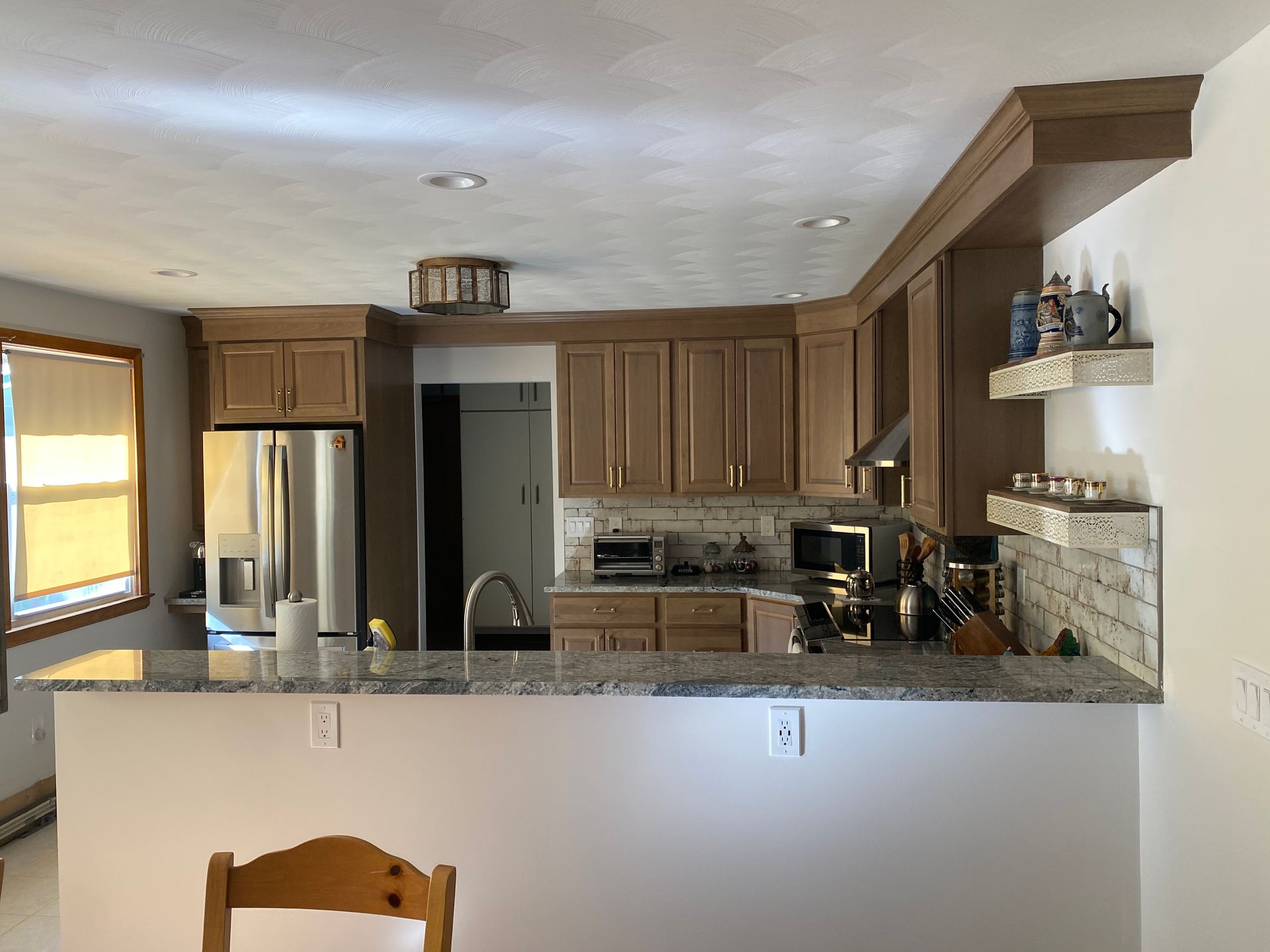 A kitchen with stainless steel appliances and wooden cabinets.
