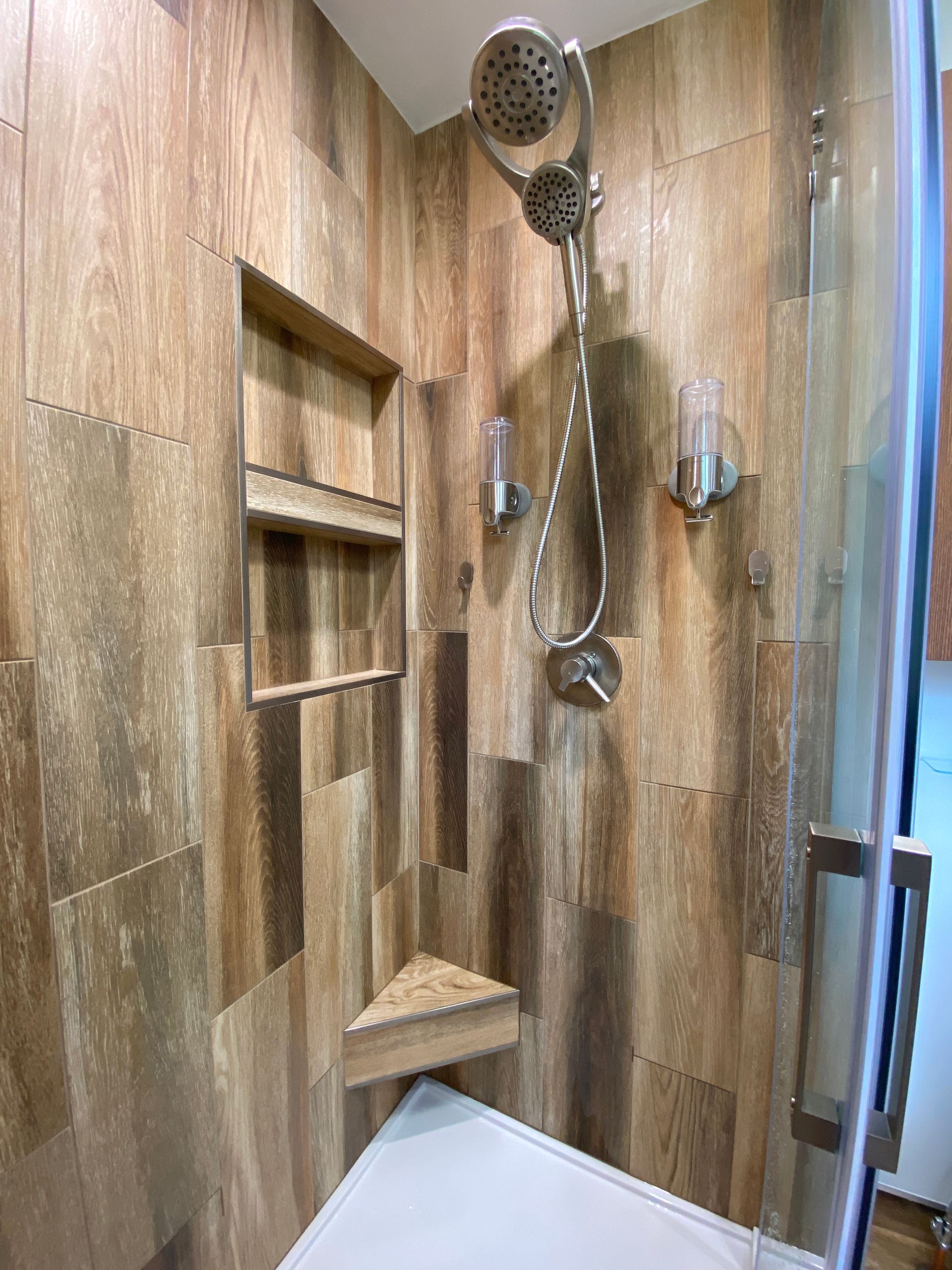 There is a shower with a glass door and a shower head.