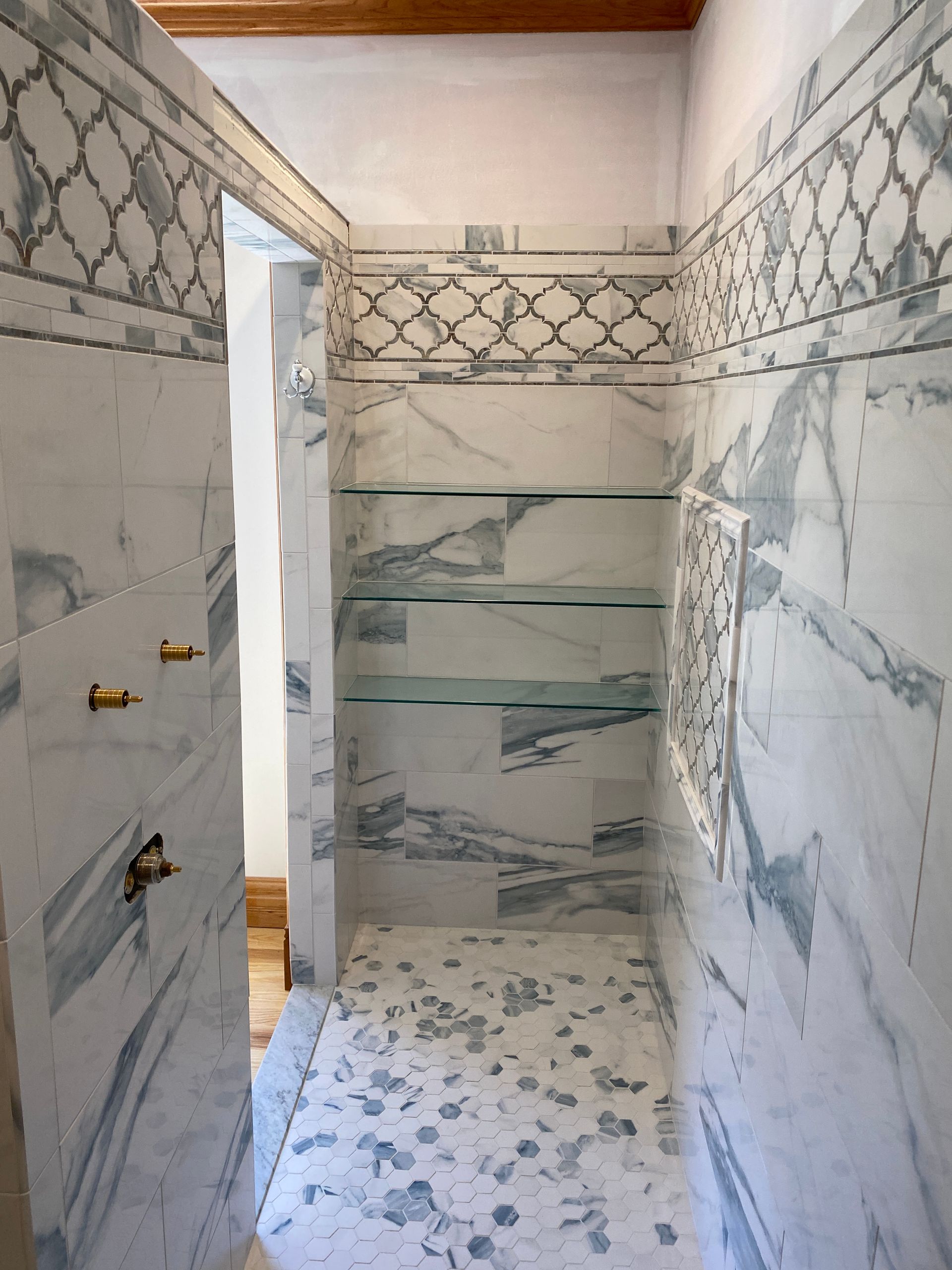 A bathroom with marble tiles and a walk in shower