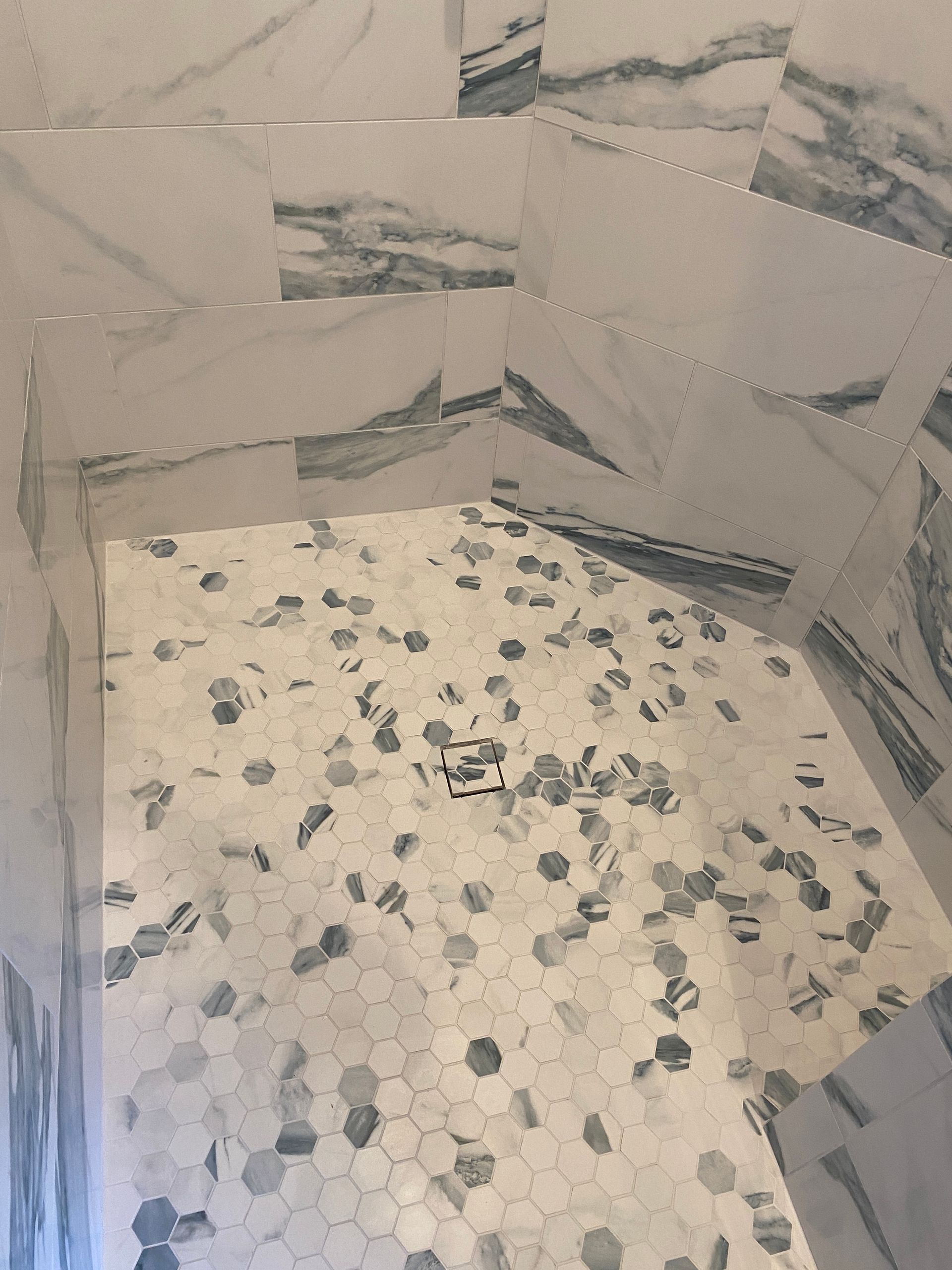 A bathroom with marble tiles and a tiled floor