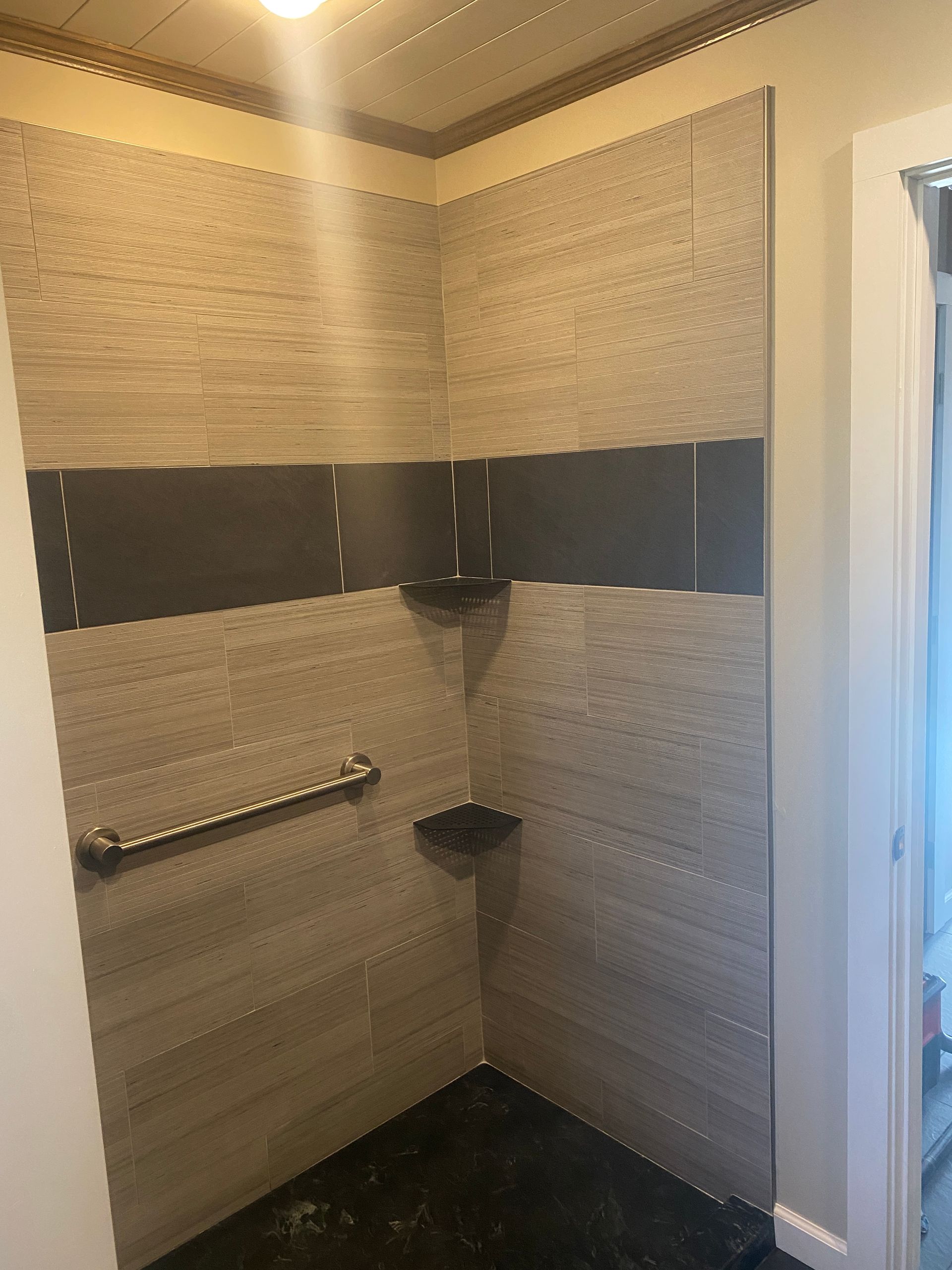 A bathroom with a walk in shower and a shelf.