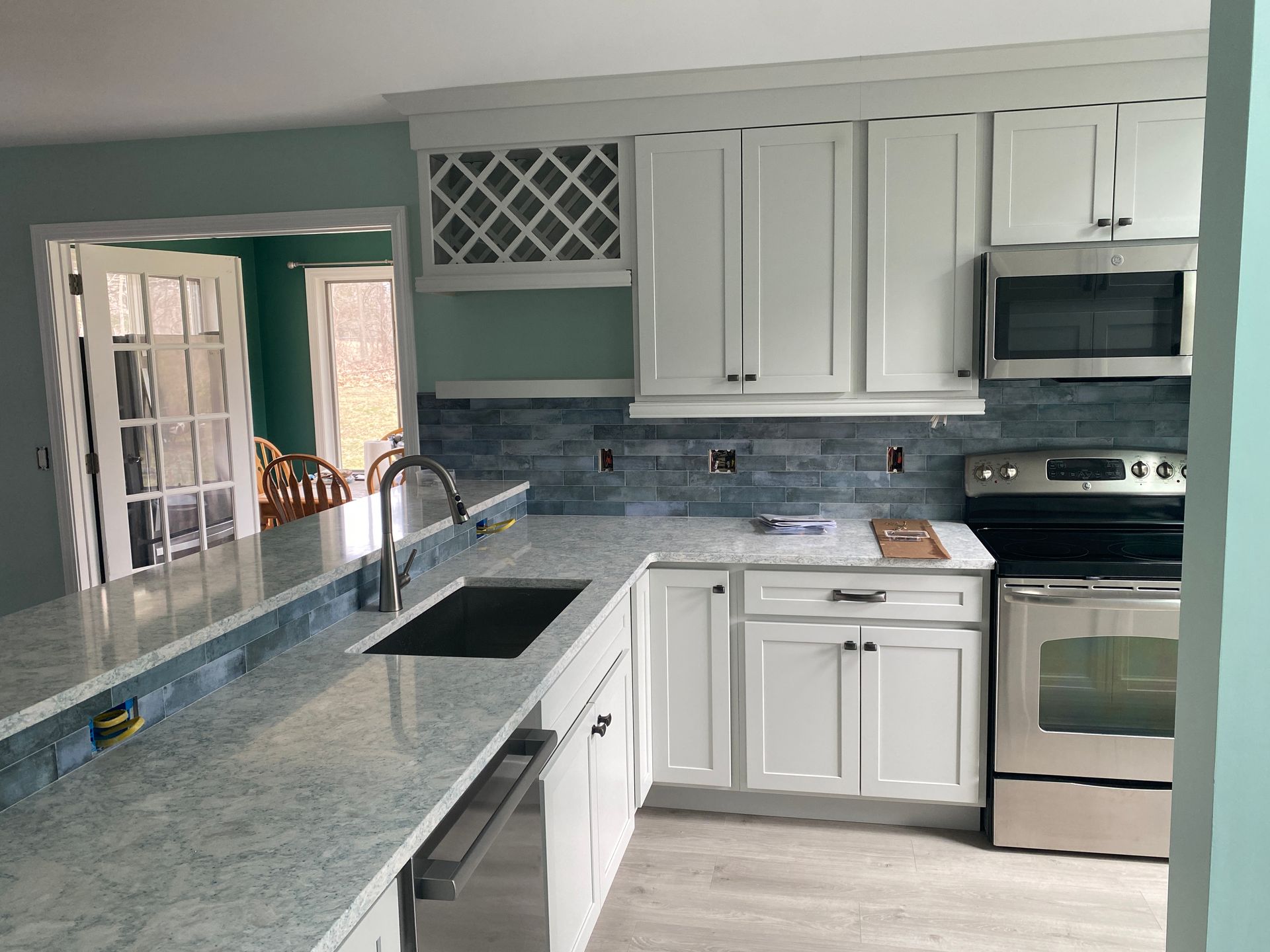 A kitchen with white cabinets and stainless steel appliances