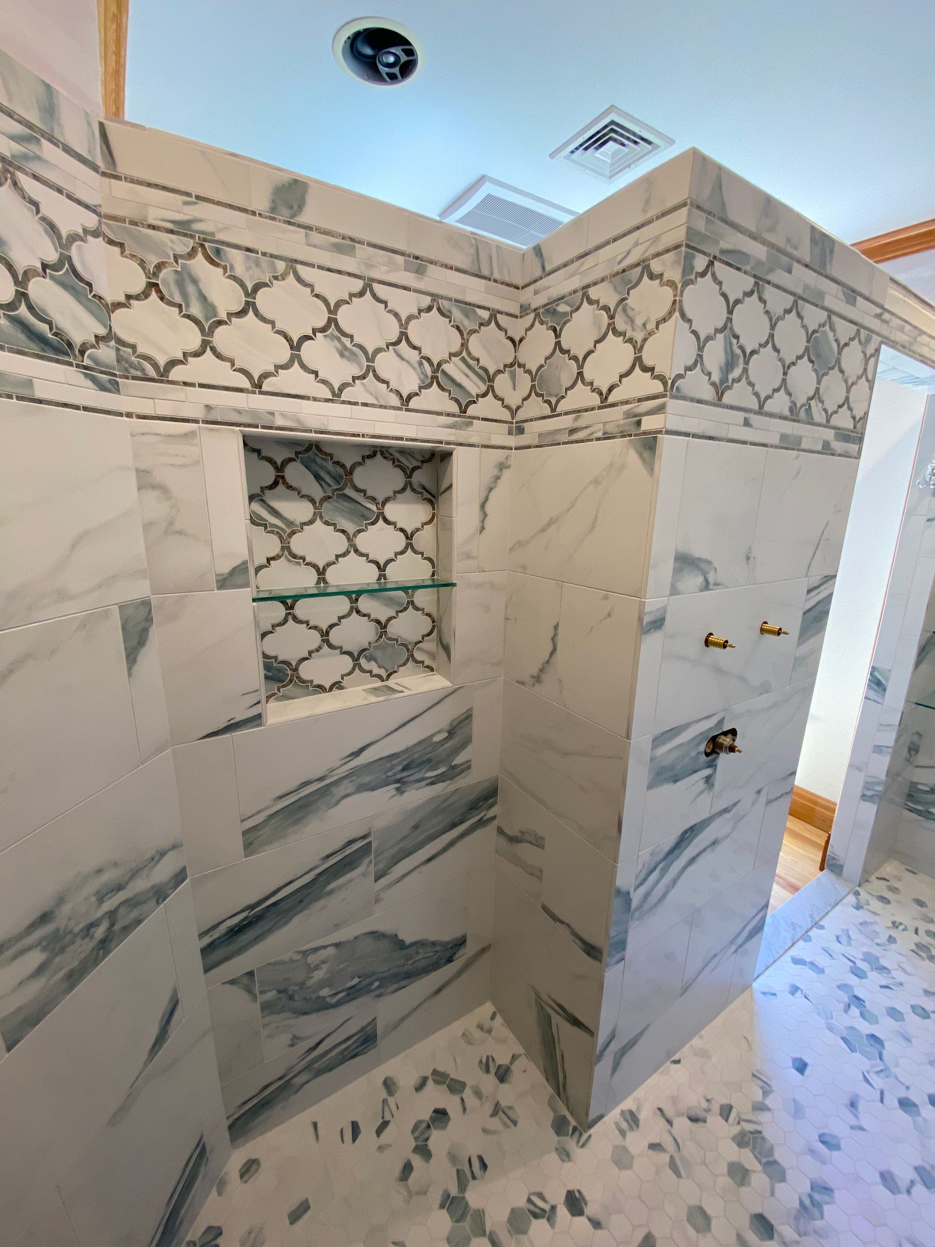 A bathroom with marble tiles and a walk in shower