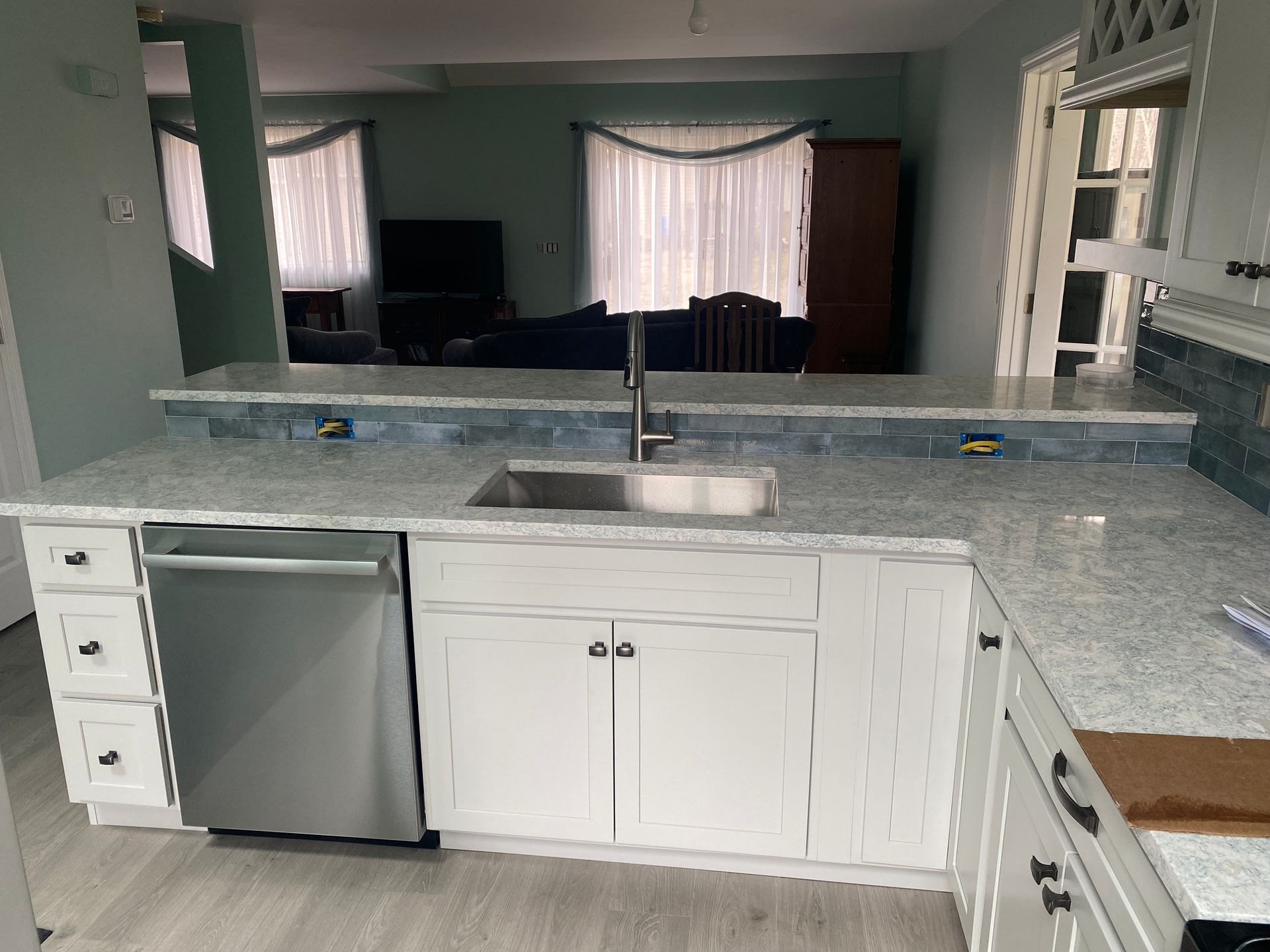 A kitchen with white cabinets and a stainless steel dishwasher