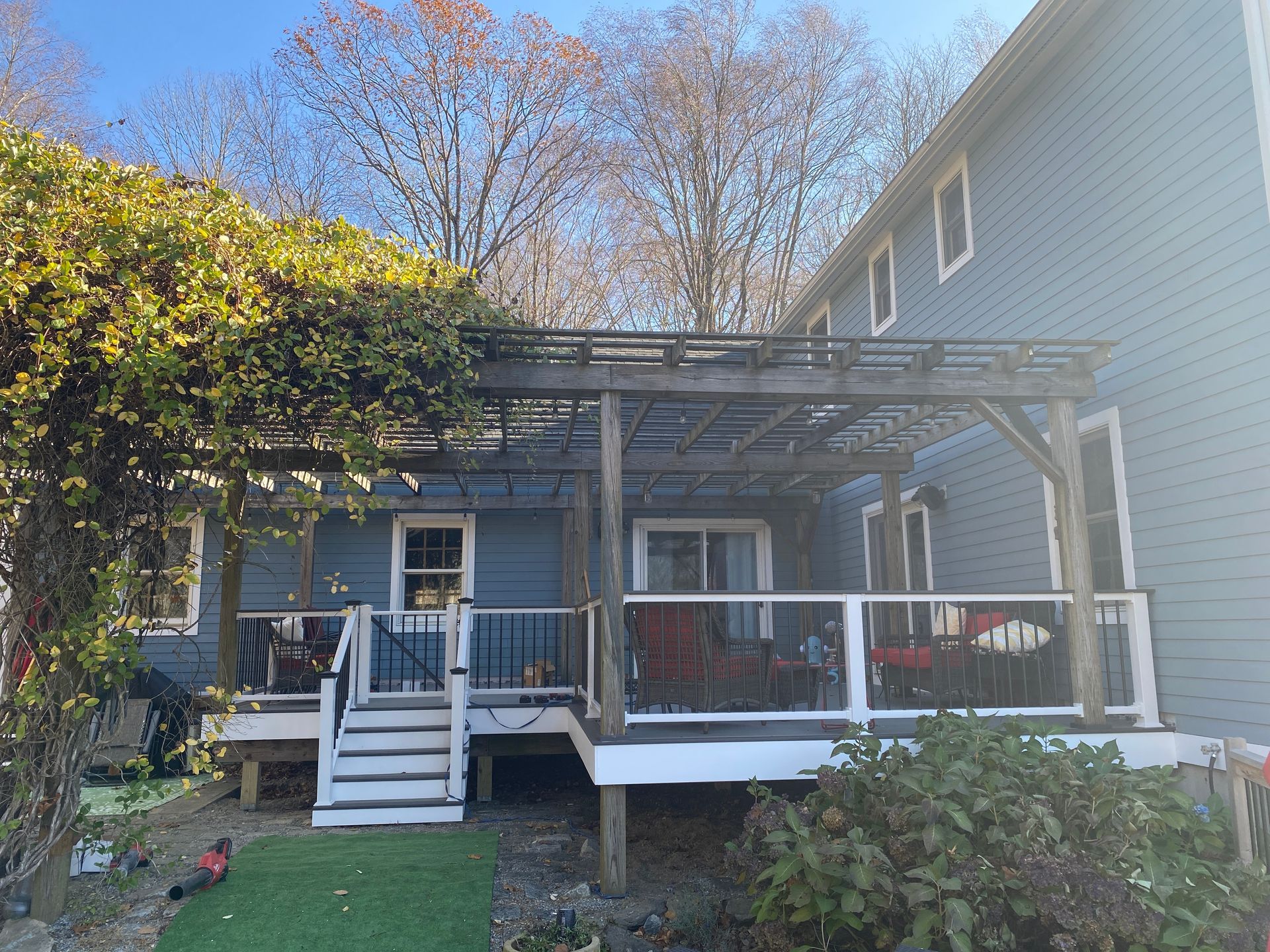 The back of a house with a large deck and a pergola.