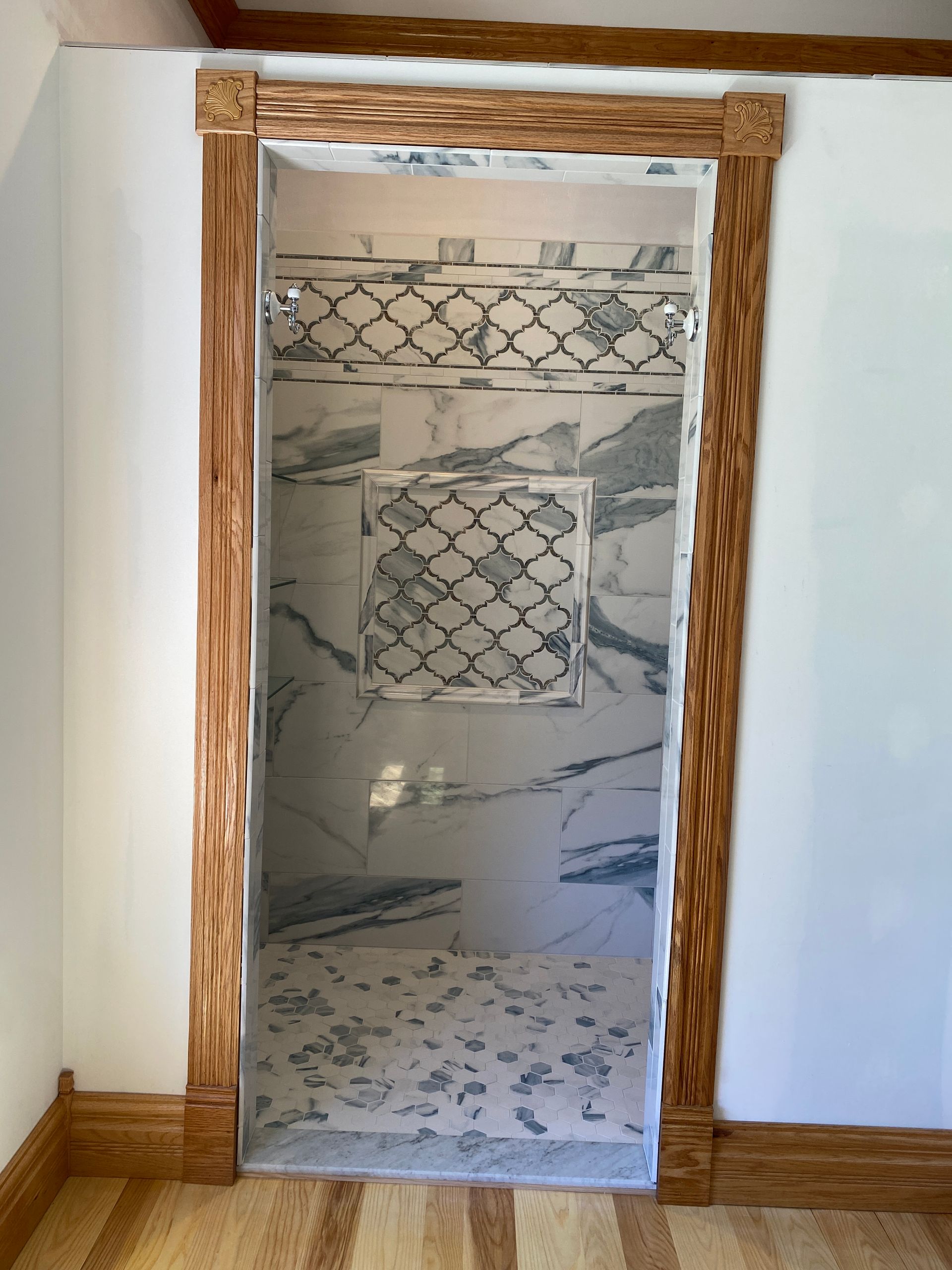 A bathroom with a walk in shower and a wooden frame