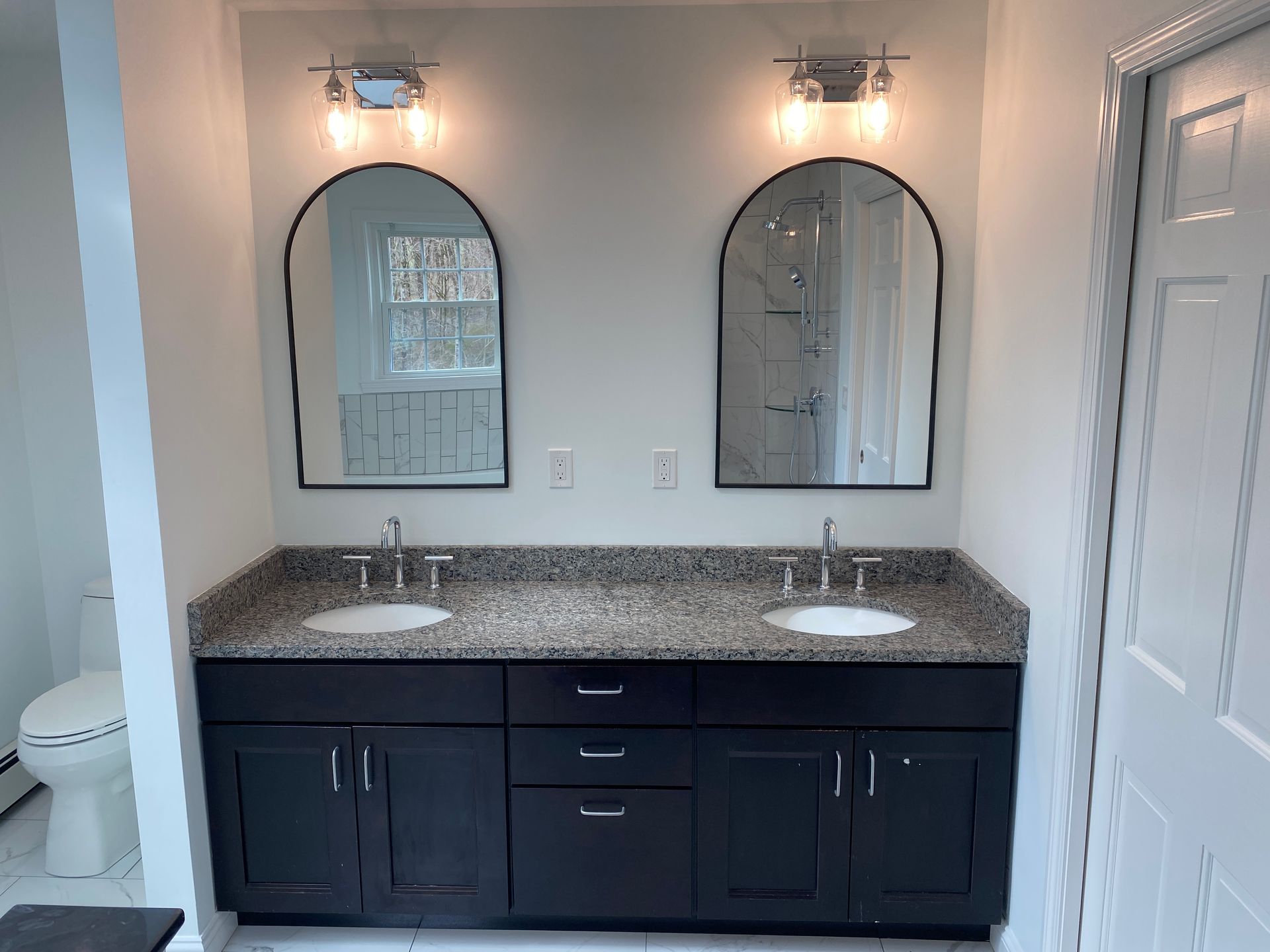 A bathroom with two sinks and two mirrors.