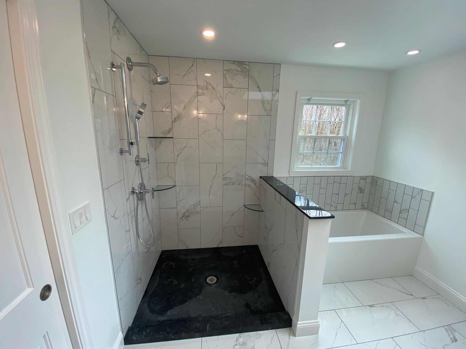 A bathroom with a walk in shower and a bathtub