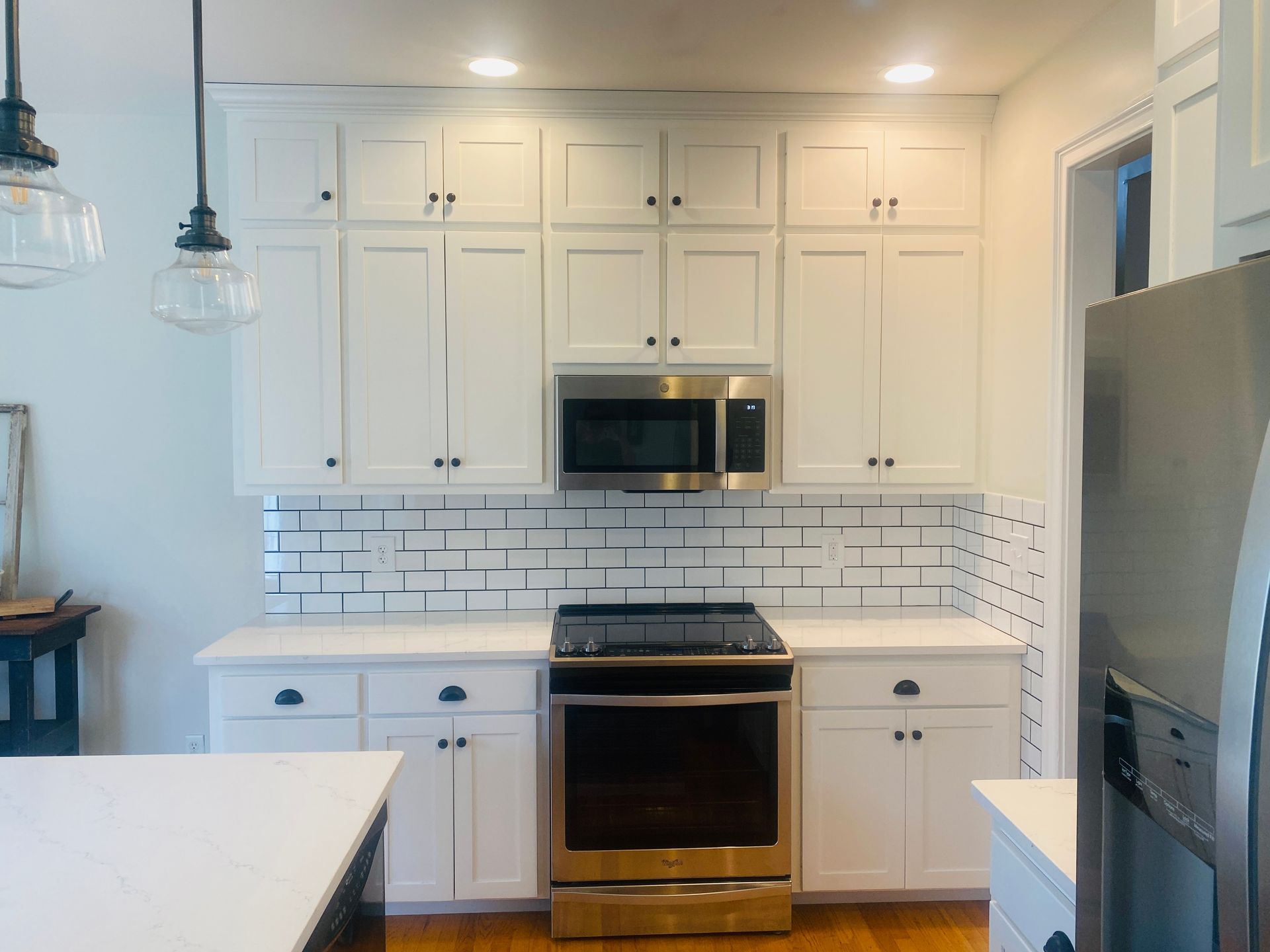 A kitchen with white cabinets and stainless steel appliances
