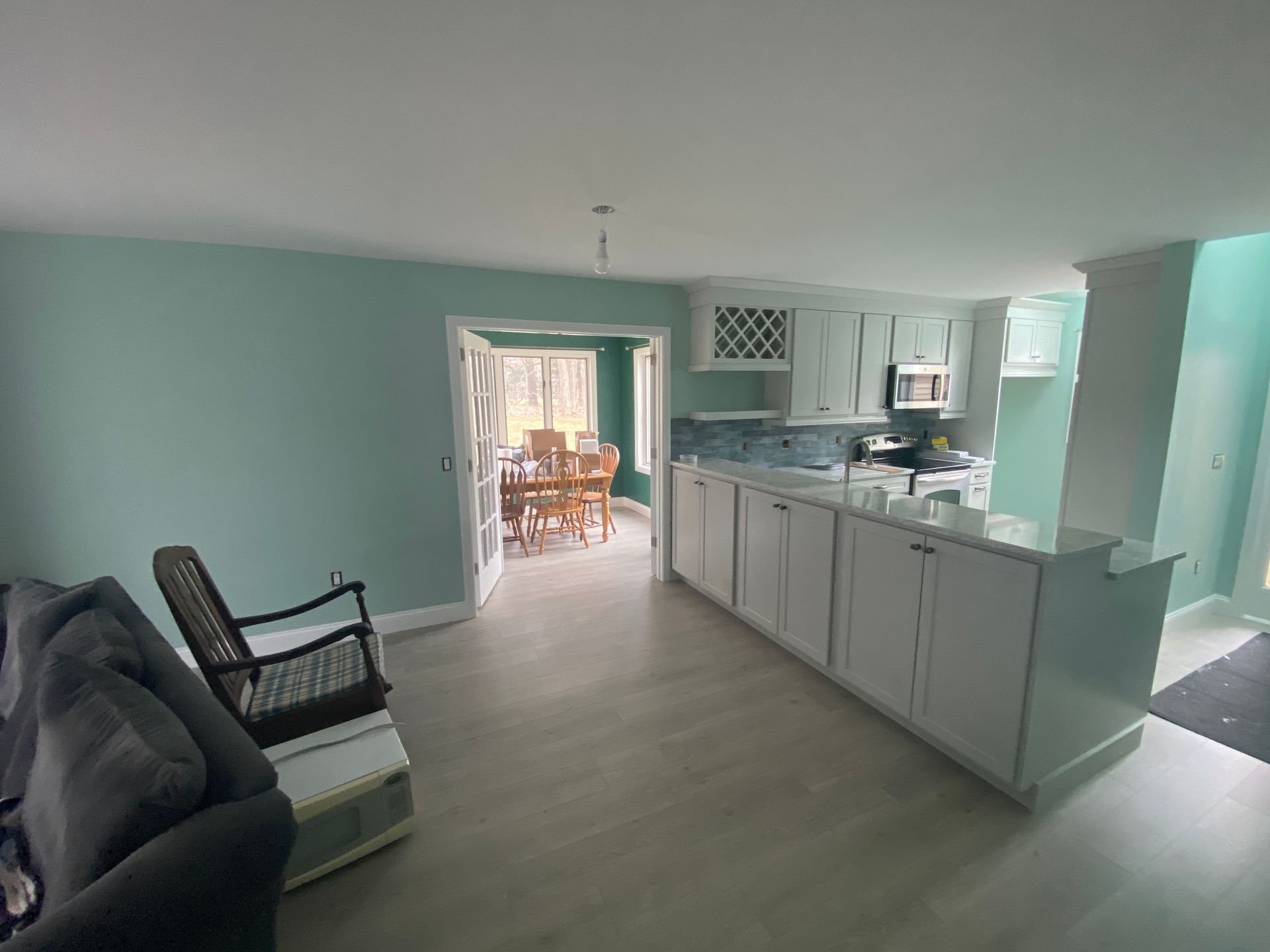 A living room with a couch , chair , table and kitchen.