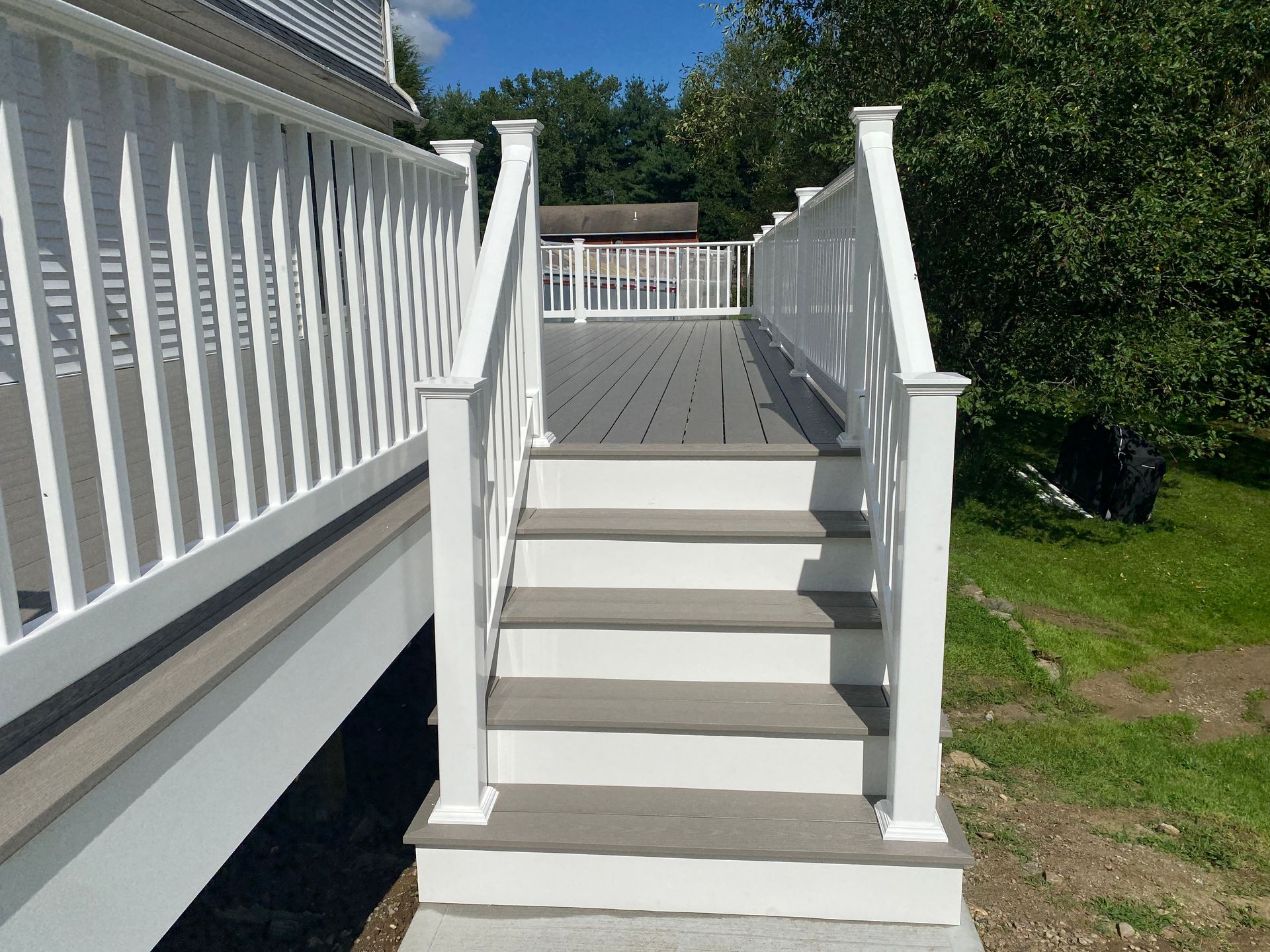 A deck with stairs leading up to it and a white railing