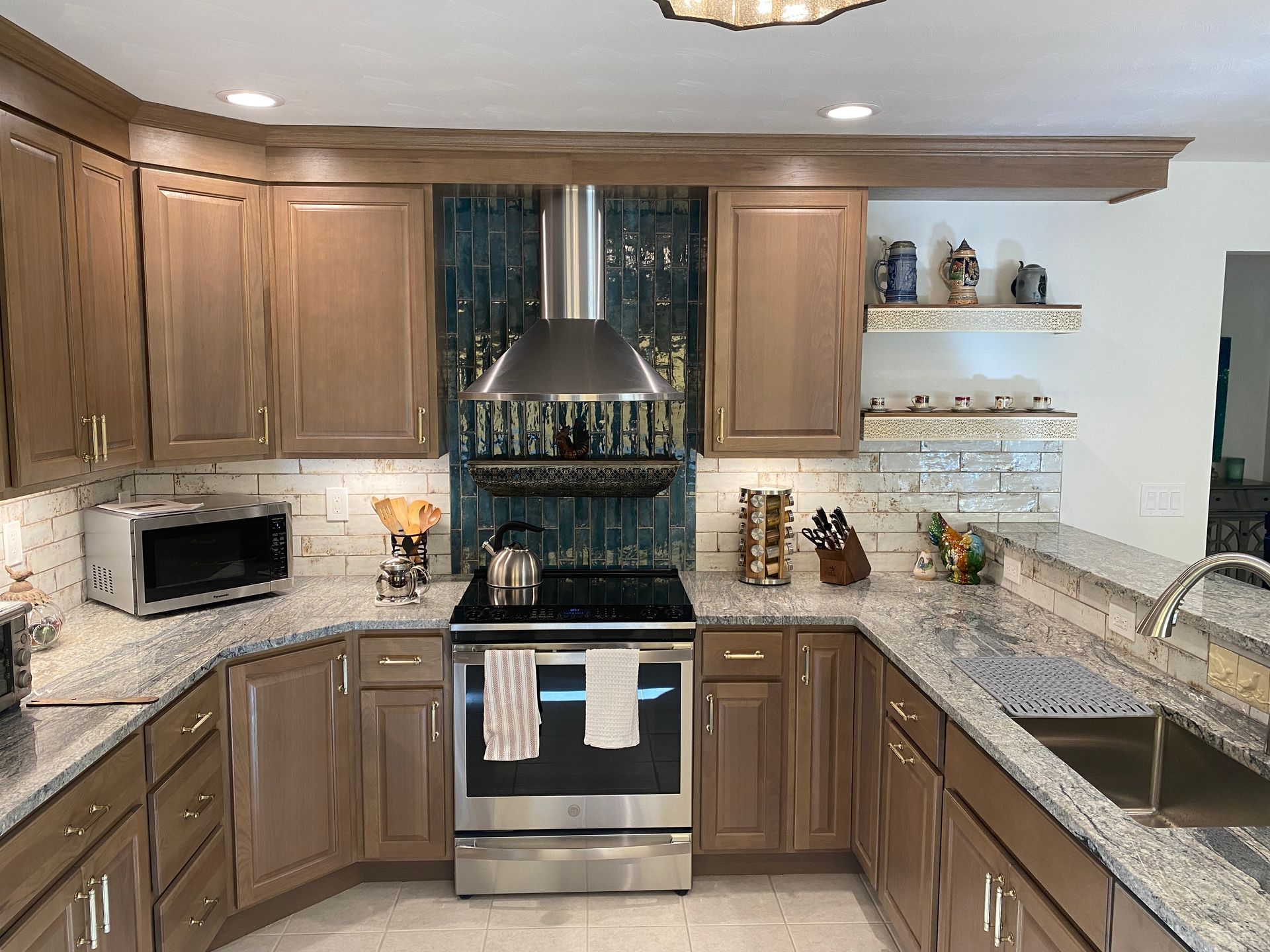 A kitchen with stainless steel appliances , granite counter tops , and wooden cabinets.