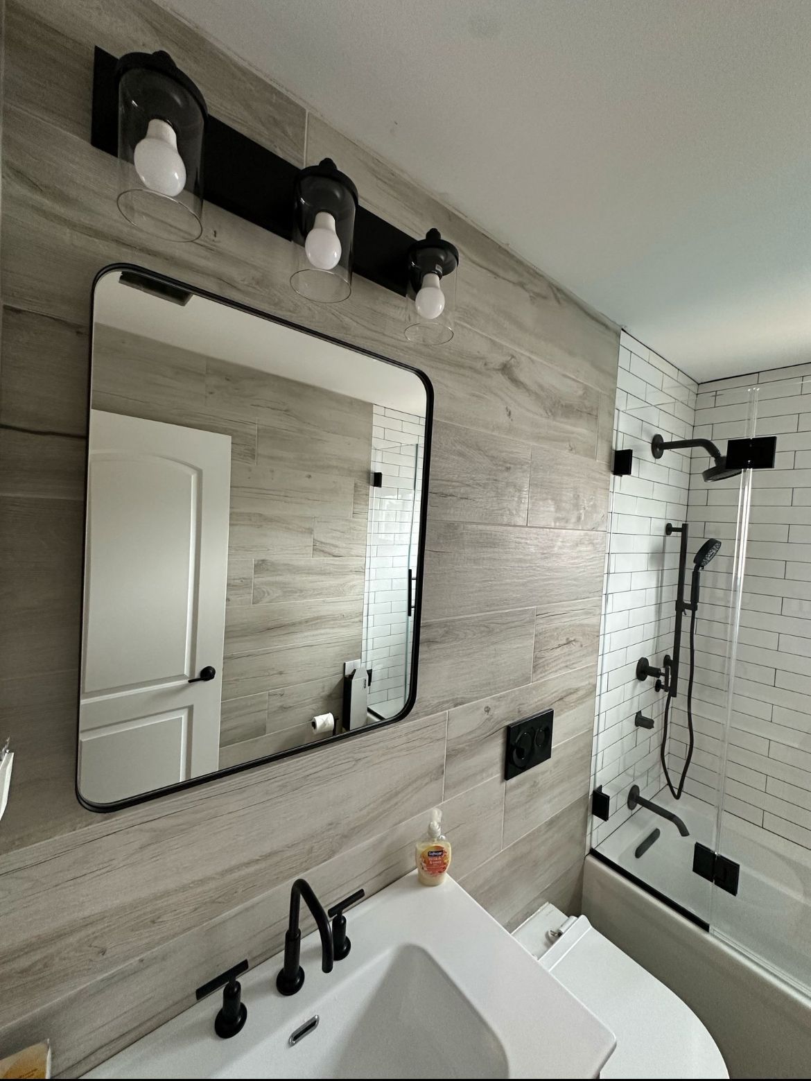 A bathroom with a sink a mirror and a bathtub