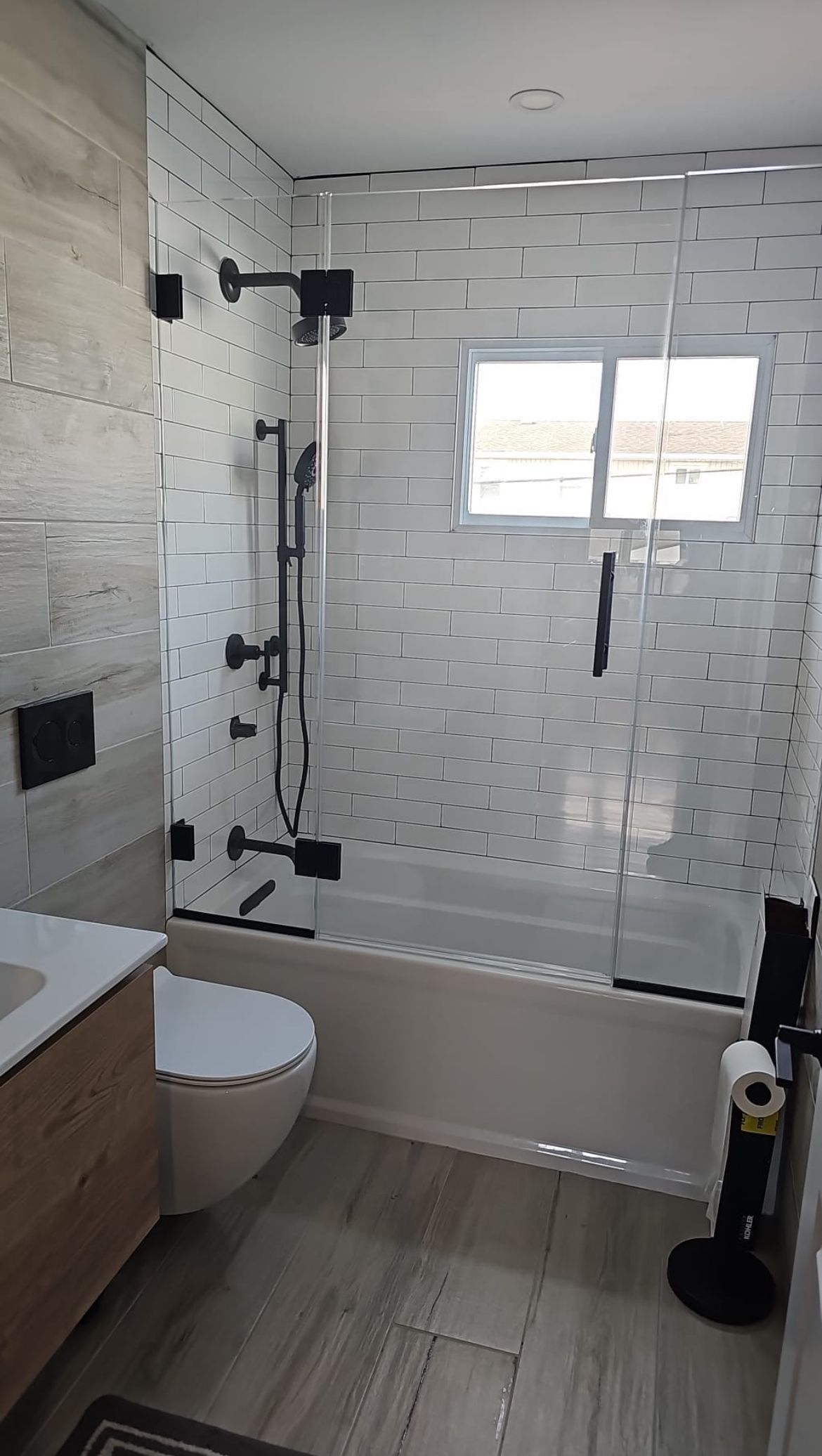 A bathroom with a tub , toilet , sink and shower.