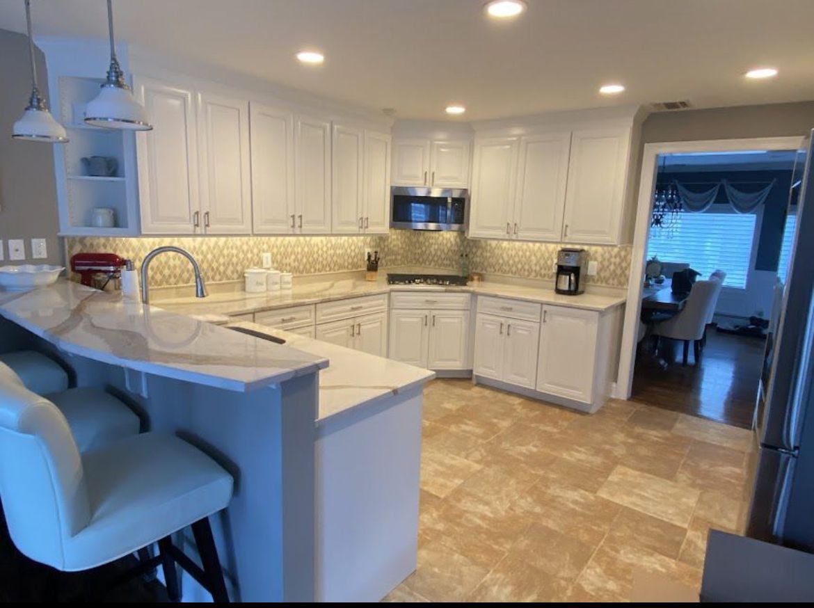 A kitchen with white cabinets, granite counter tops, and stainless steel appliances
