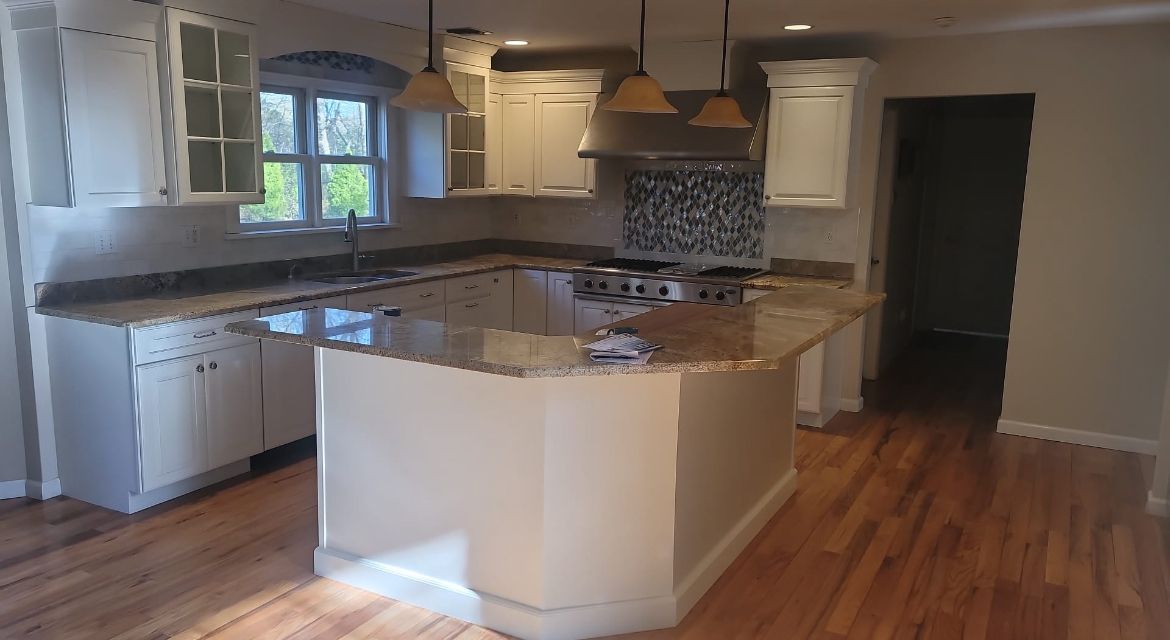 A kitchen with white cabinets and granite counter tops