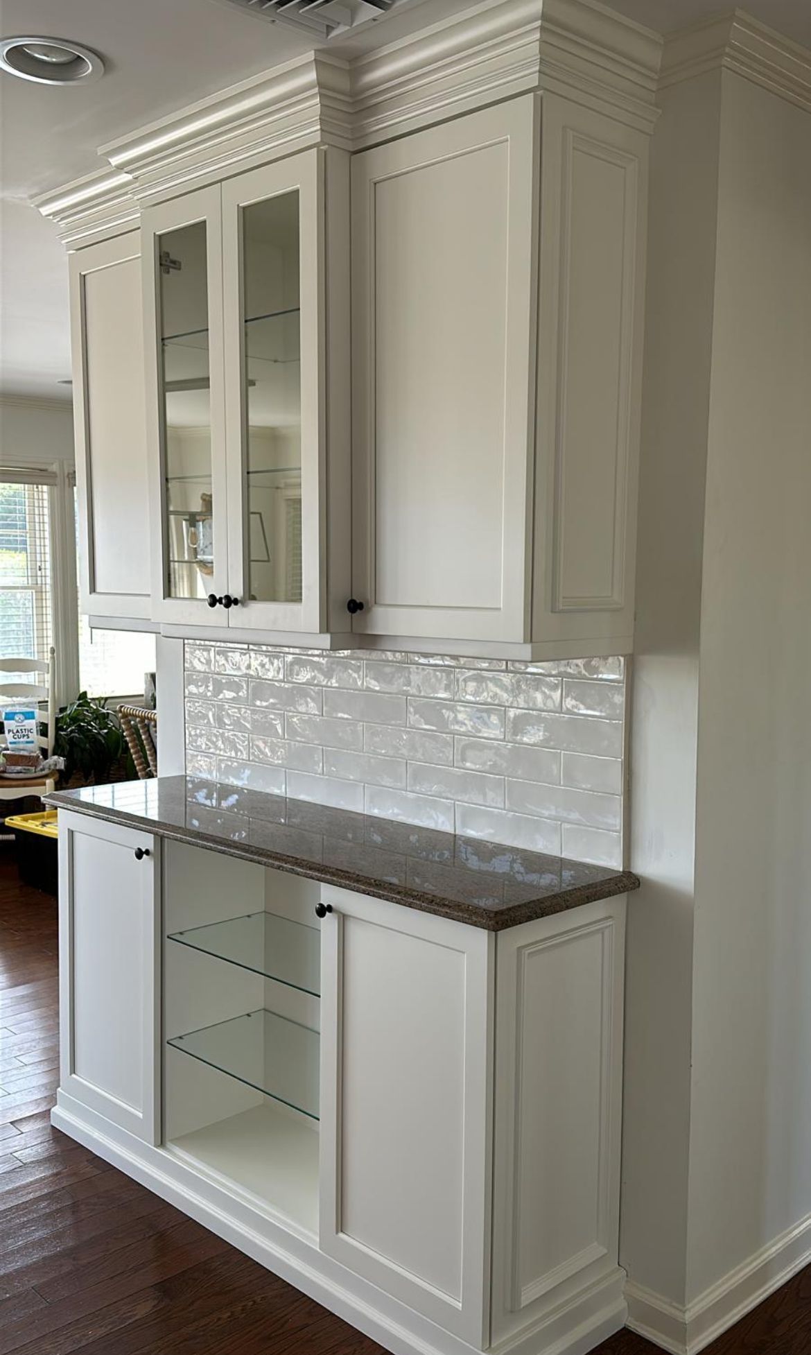 A kitchen with white cabinets and a granite counter top.