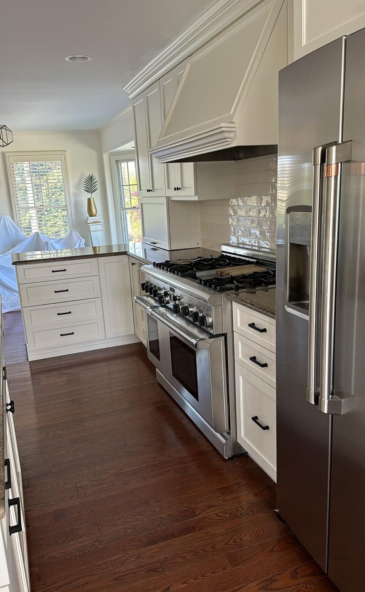 A kitchen with stainless steel appliances and white cabinets.