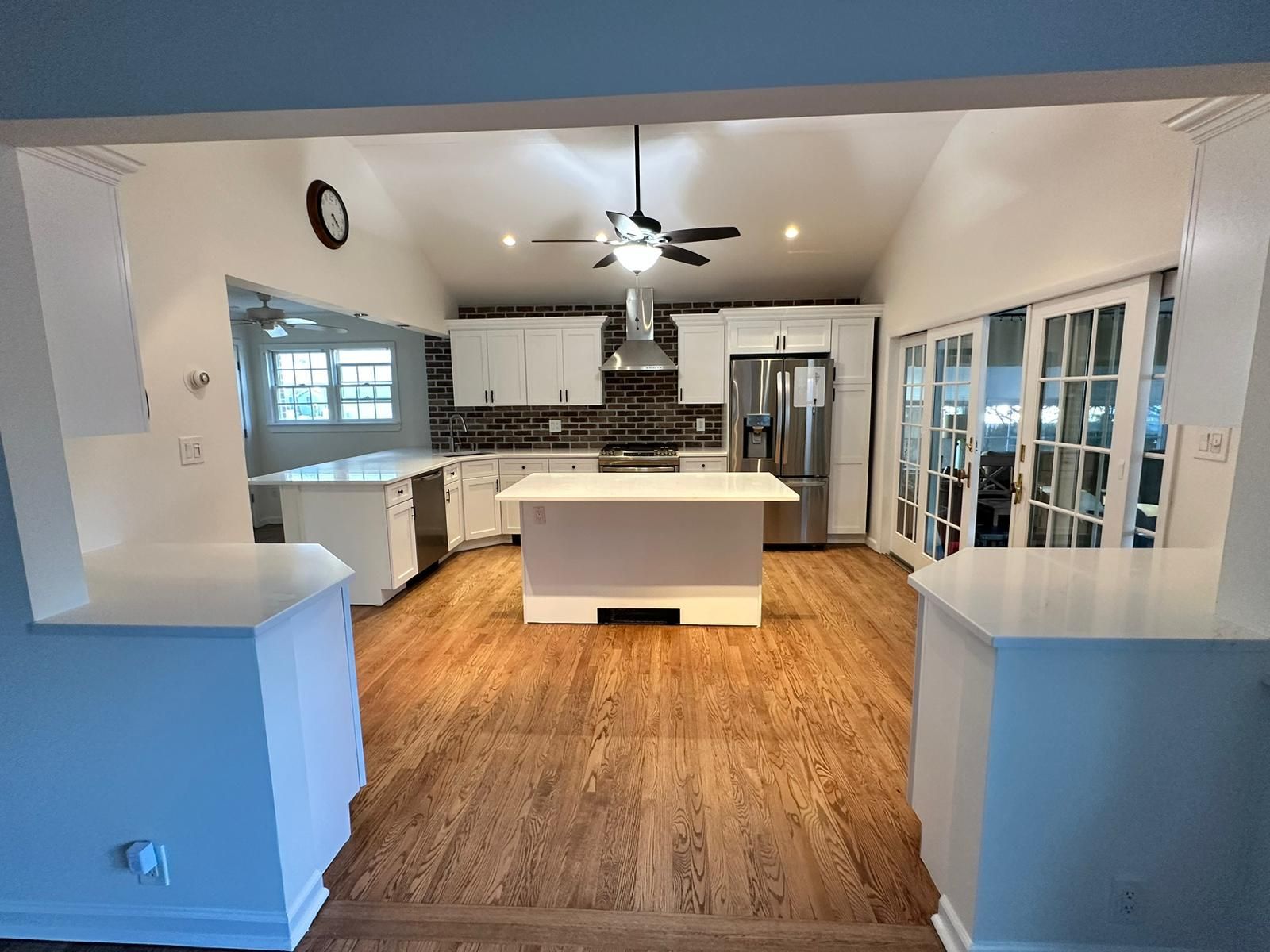 A kitchen with a large island in the middle of it and a ceiling fan.