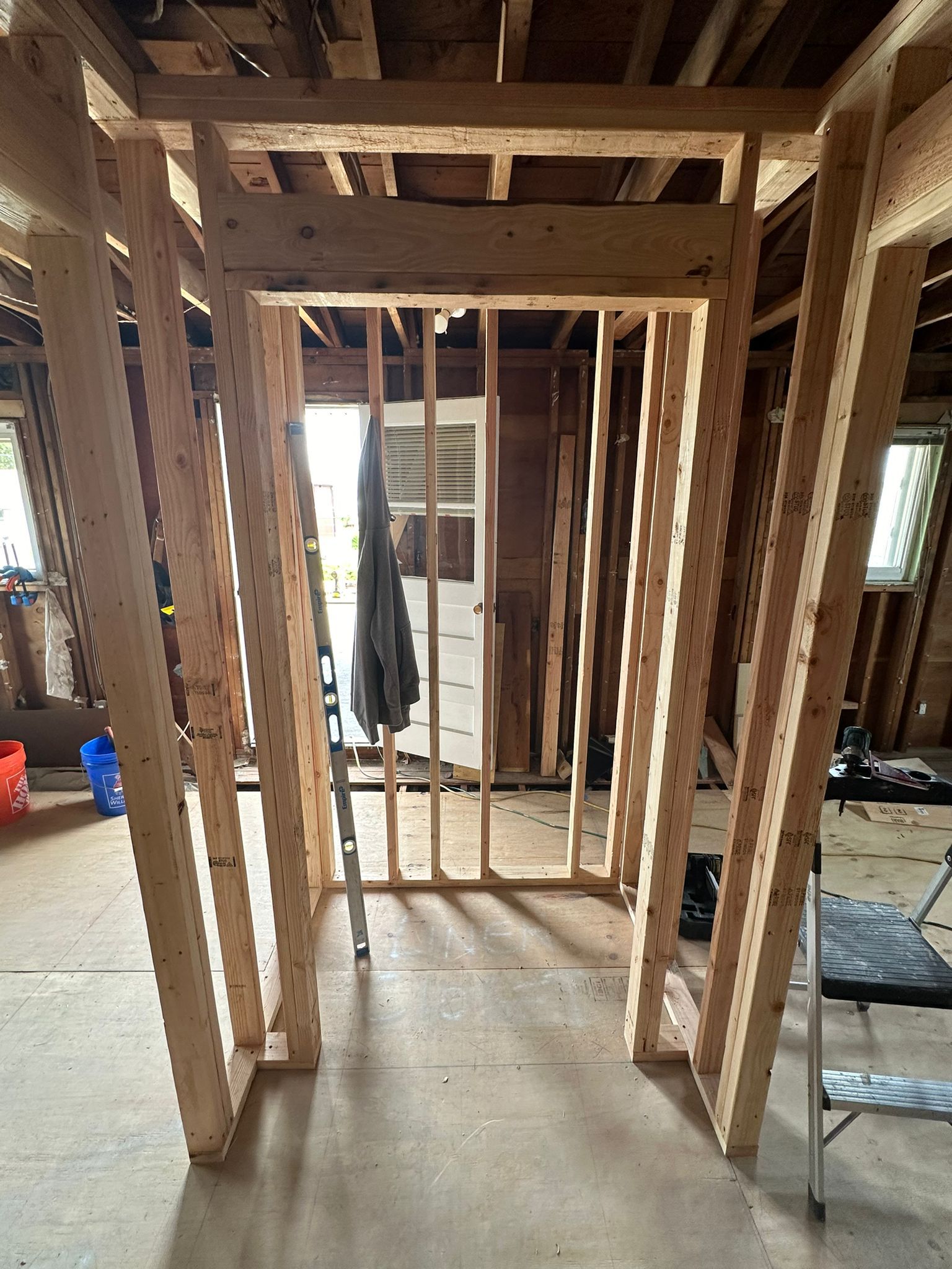 A room under construction with wooden beams and a door.