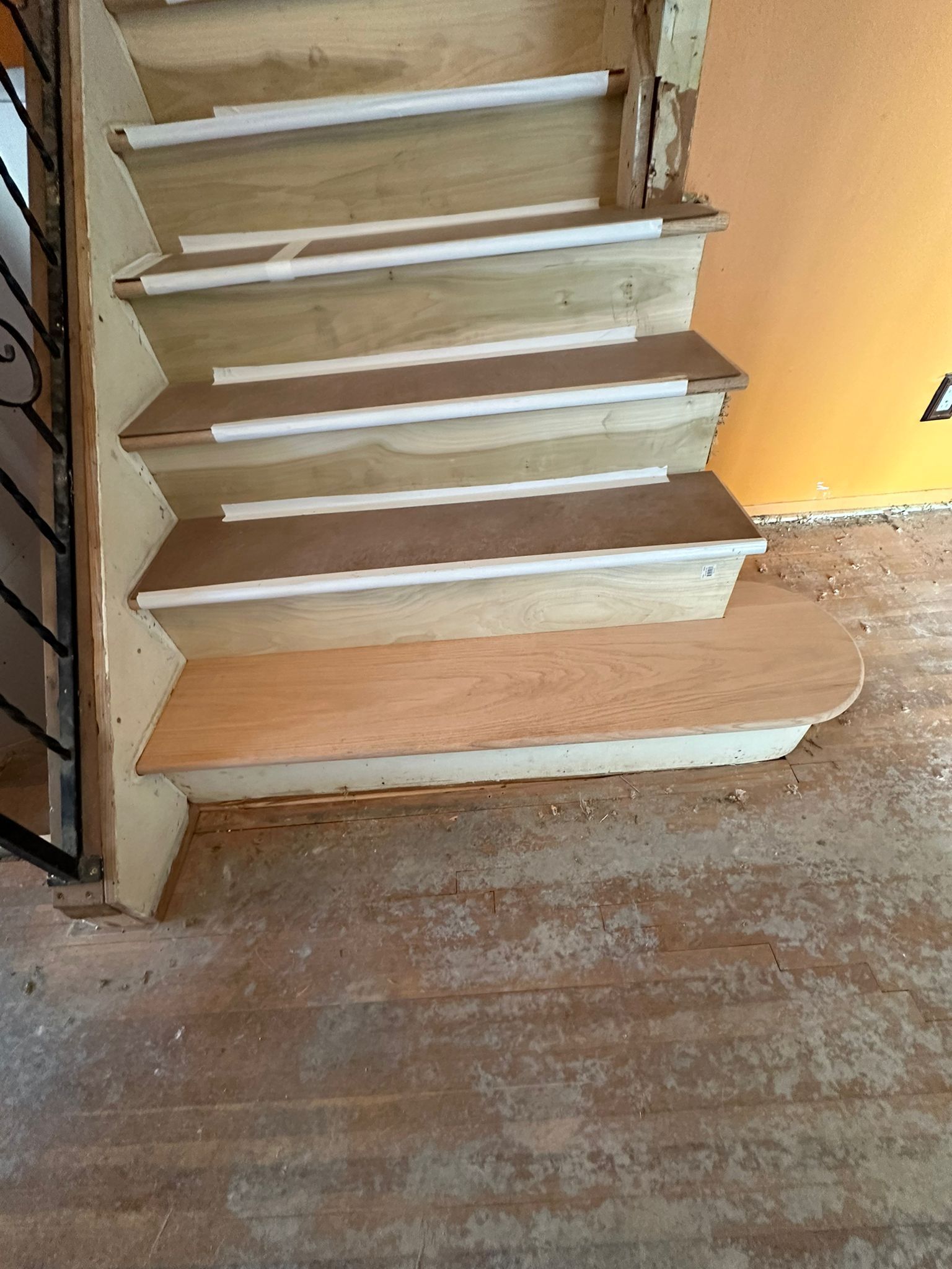 A wooden staircase with a metal railing in a room