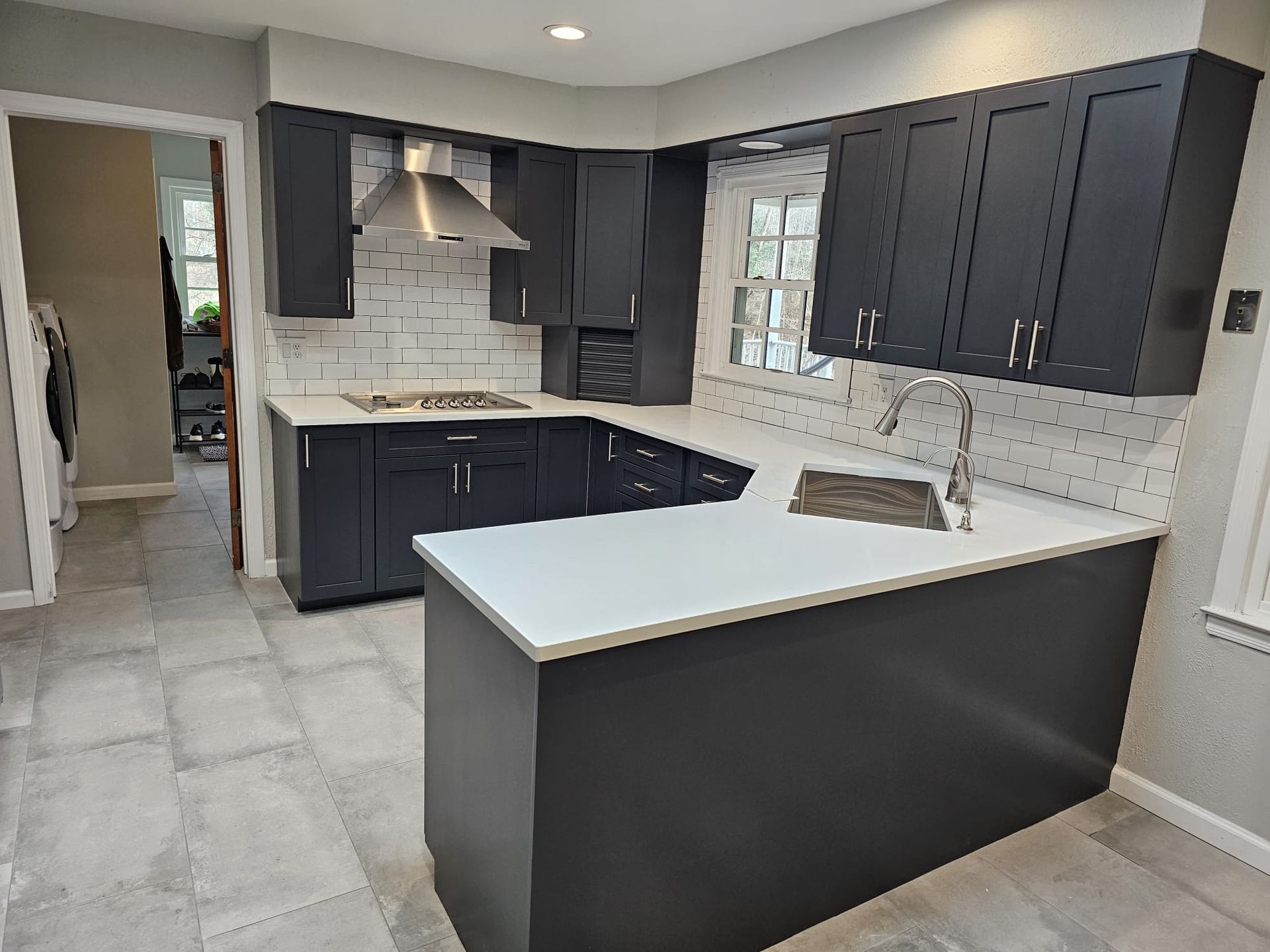 A kitchen with black cabinets and a white counter top.