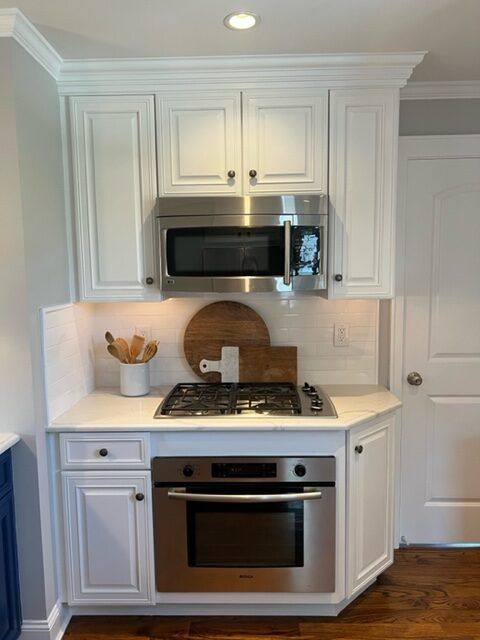 A kitchen with stainless steel appliances and white cabinets