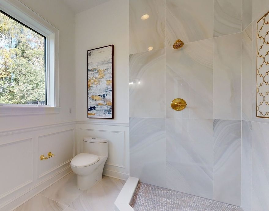 A bathroom with a toilet and a walk in shower.