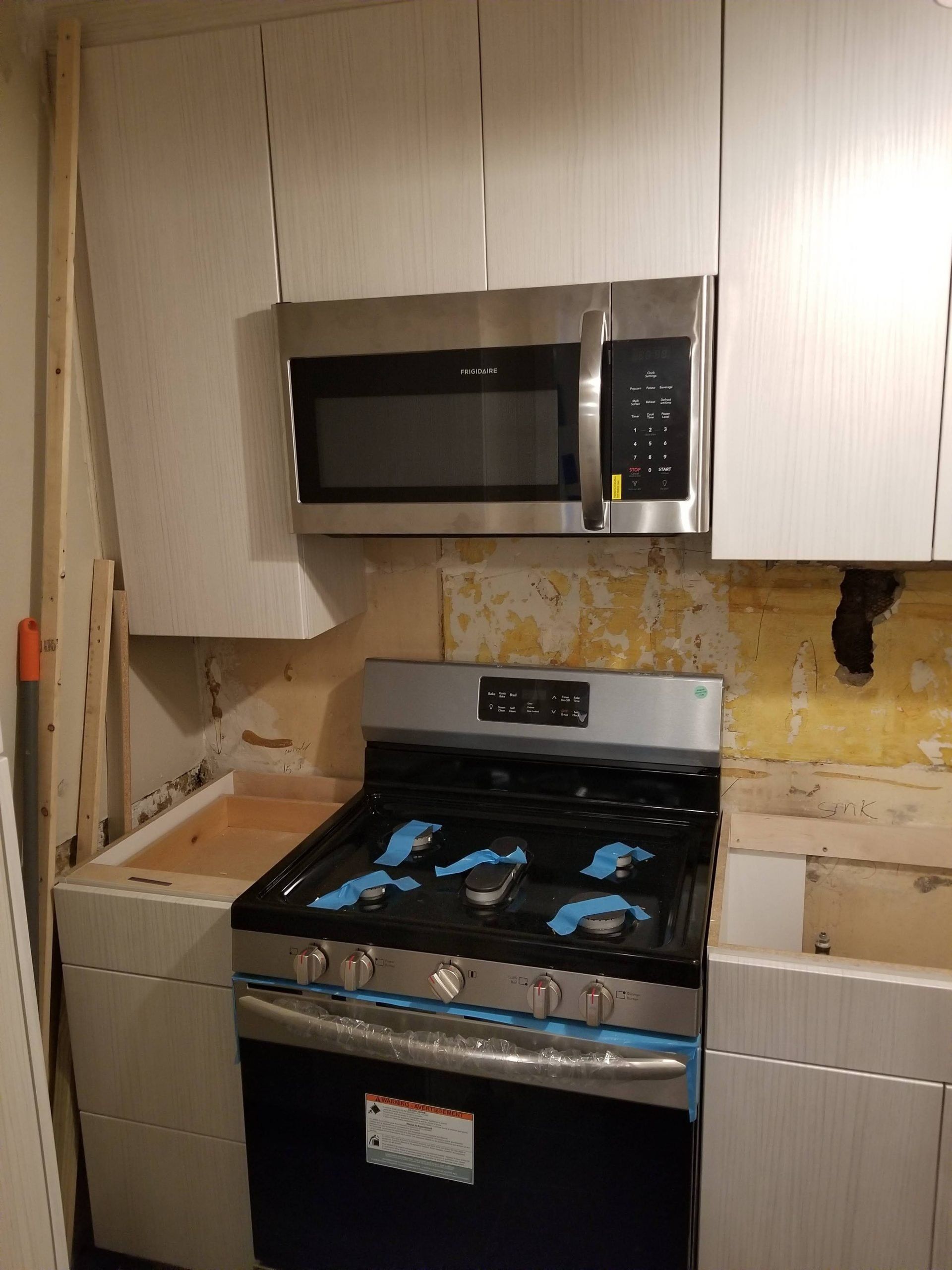 A kitchen with a stove top oven and a microwave