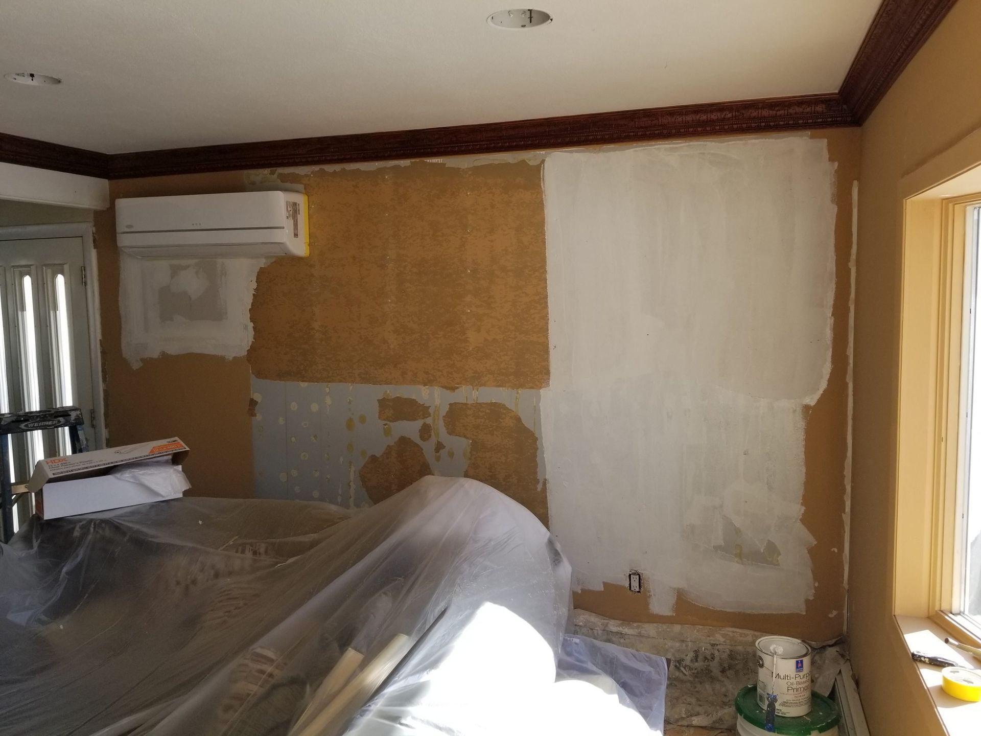 A room that is being painted with a ladder in the background