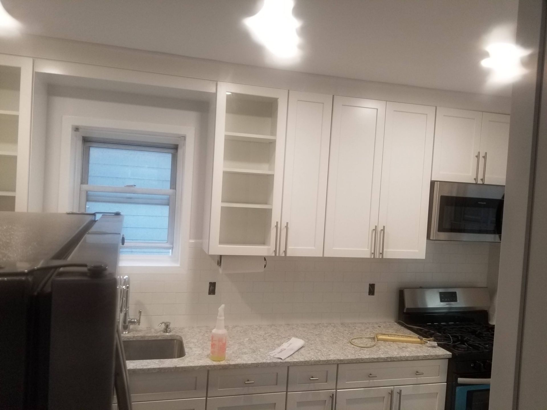 A kitchen with white cabinets and granite counter tops