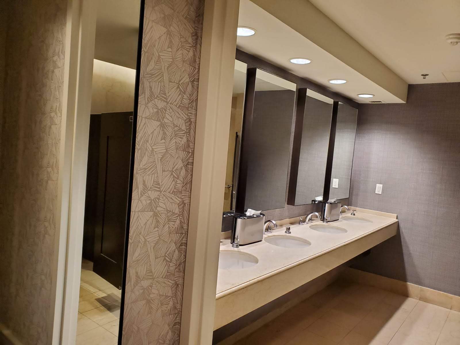 A bathroom with a row of sinks and mirrors