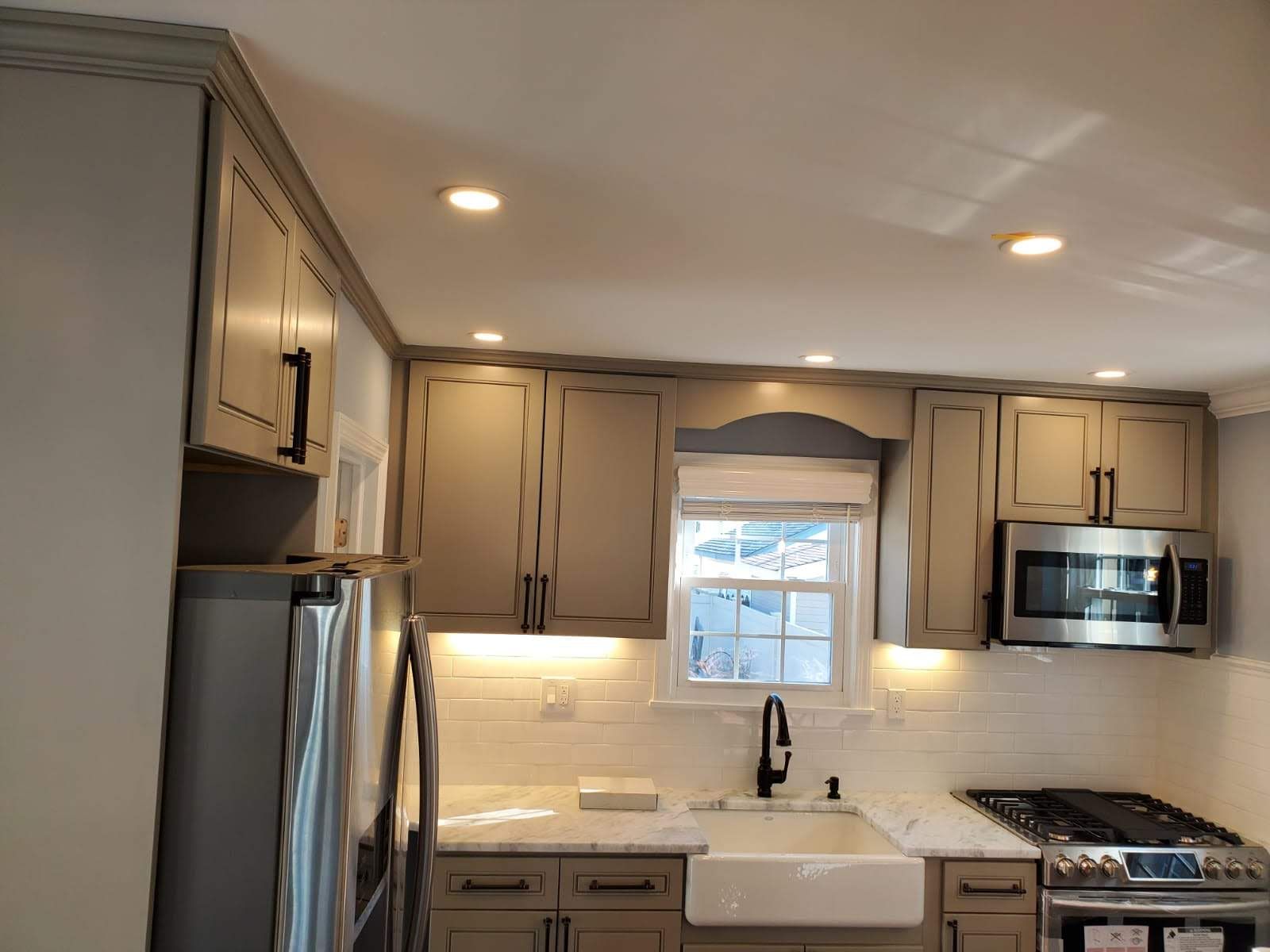 A kitchen with stainless steel appliances and gray cabinets