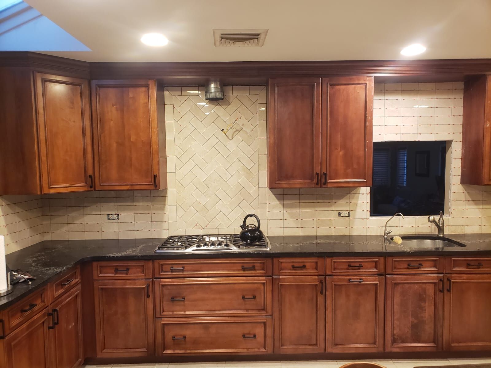 A kitchen with wooden cabinets and a stove top oven