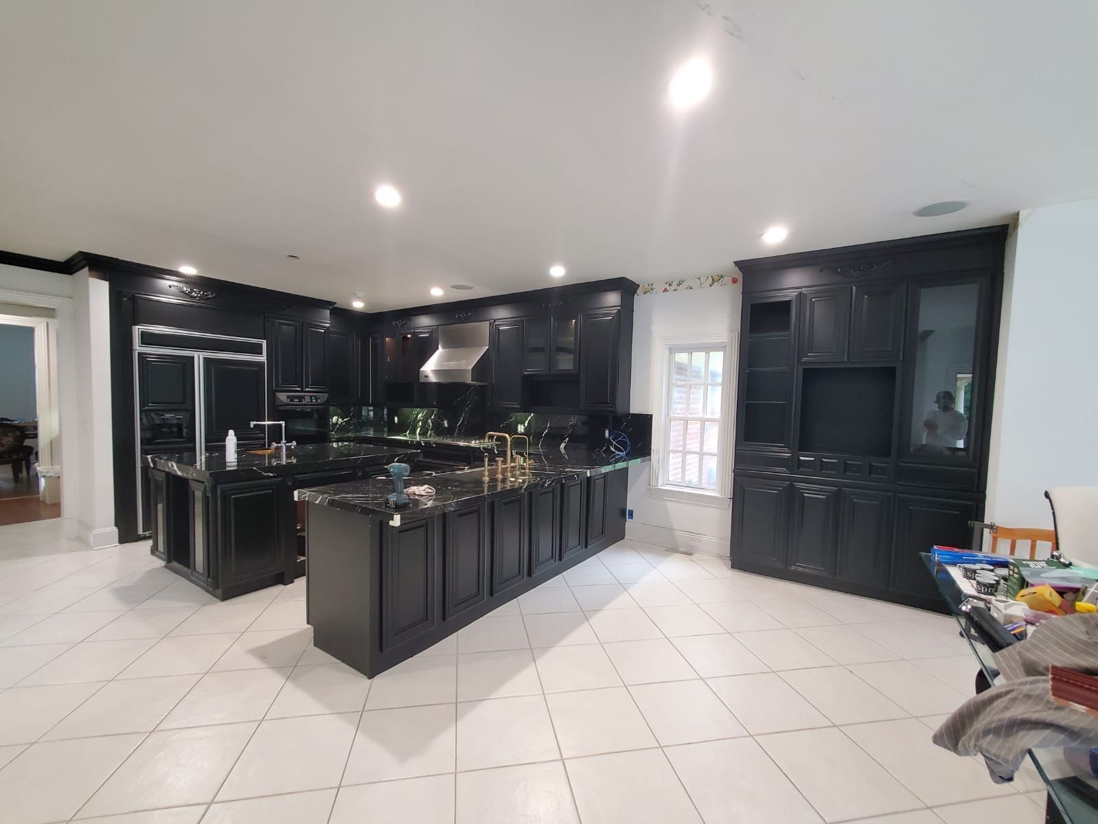 A large kitchen with black cabinets and stainless steel appliances.