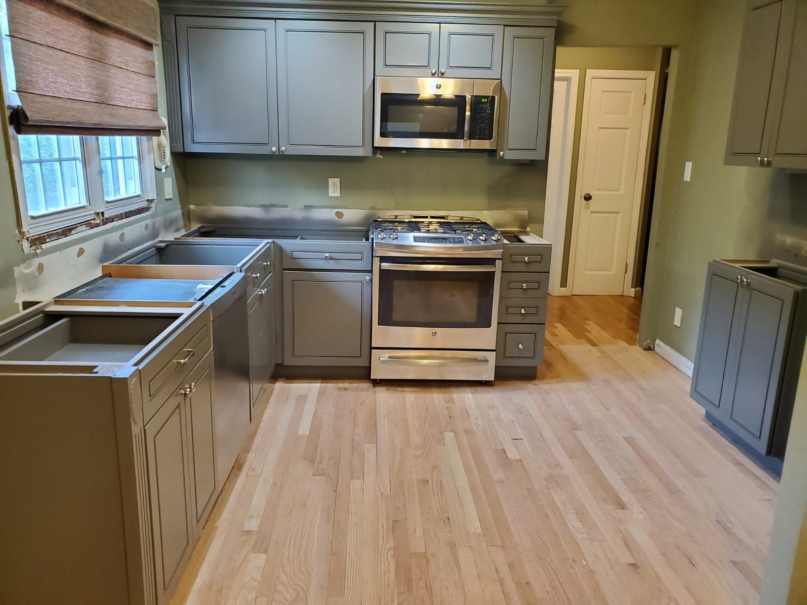 A kitchen with stainless steel appliances and gray cabinets